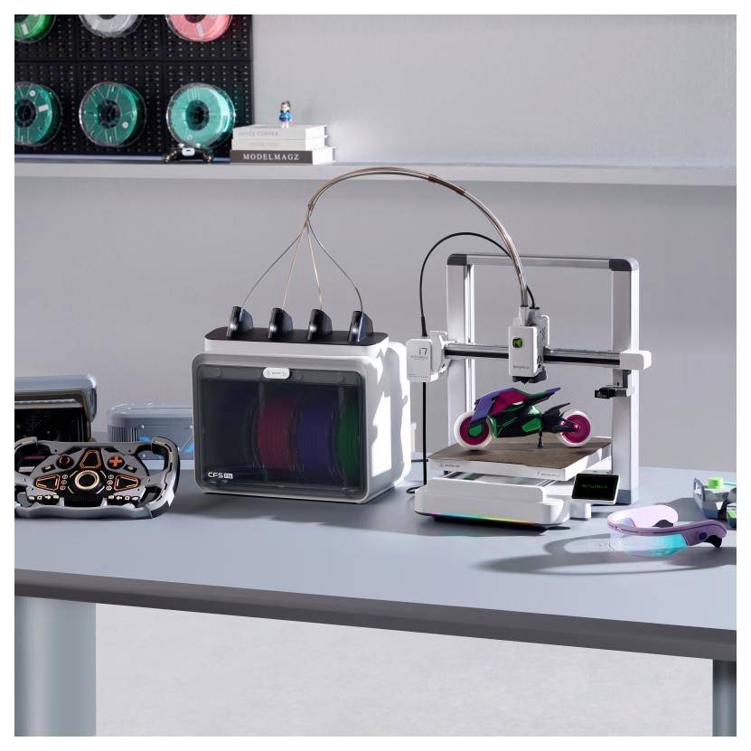 Ein 3D-Drucker auf einem Schreibtisch druckt ein kleines, buntes Modell, mit Prototypteilen und Druckerkomponenten, die um ihn herum angeordnet sind.