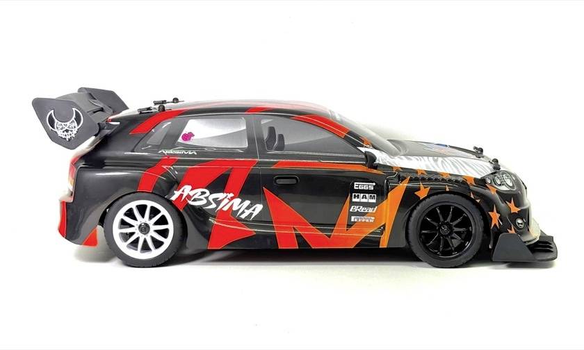 Seitenansicht eines schwarzen und roten Rennmodell-Autos mit einem großen Heck-Flügel und Sponsor-Aufklebern auf weißem Hintergrund.