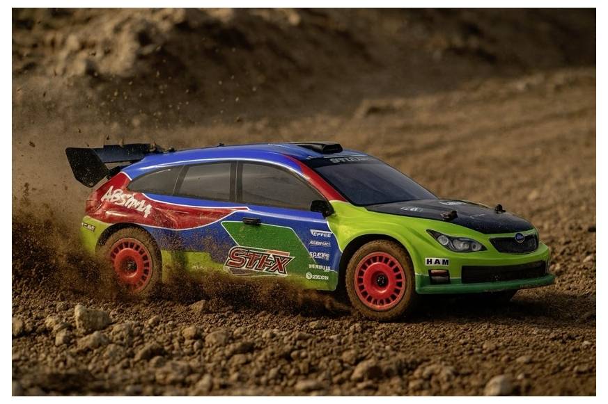 Ein farbenfroher Rallyewagen rast über eine Schotterpiste, wirbelt Staub und Kies auf.
