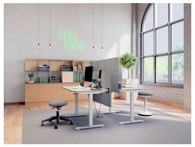 Modernes offenes Büro mit Stehschreibtischen, Computermonitoren, Regalen, Hockern, großem Fenster und Leuchtreklame mit der Aufschrift „FEEL GOOD
