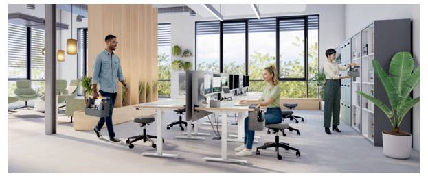 Modernes Open-Office mit zwei Personen, die an Schreibtischen arbeiten, und einem Mann, der eine Werkzeugkiste zu Lagerschränken trägt, was auf Arbeitsplatzeinrichtung oder Wartung hindeutet.