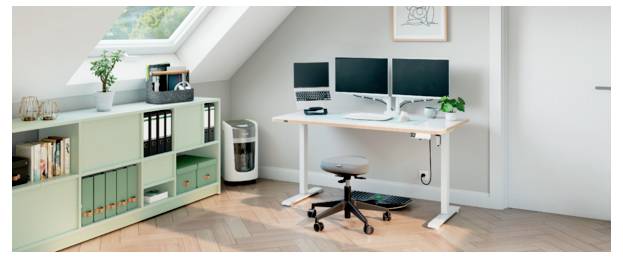 Modernes Homeoffice mit zwei Monitoren auf einem weißen Schreibtisch, Drehstuhl, Regalen, Drucker und Dachfenster in einem hellen Dachzimmer.