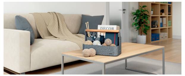 Wohnzimmer mit beigem Sofa und Couchtisch, auf dem ein Wollhandwerk-Korb mit der Aufschrift „DECOR