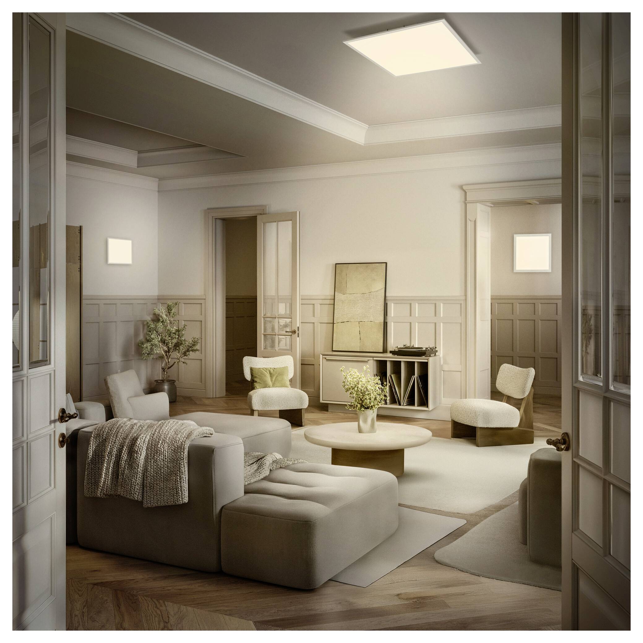 Elegantes modernes Wohnzimmer mit neutralen Sitzmöbeln, rundem Couchtisch, sanfter Beleuchtung, Wandkunst und offenen Doppeltüren, fotografiert vom Eingangsbereich aus.