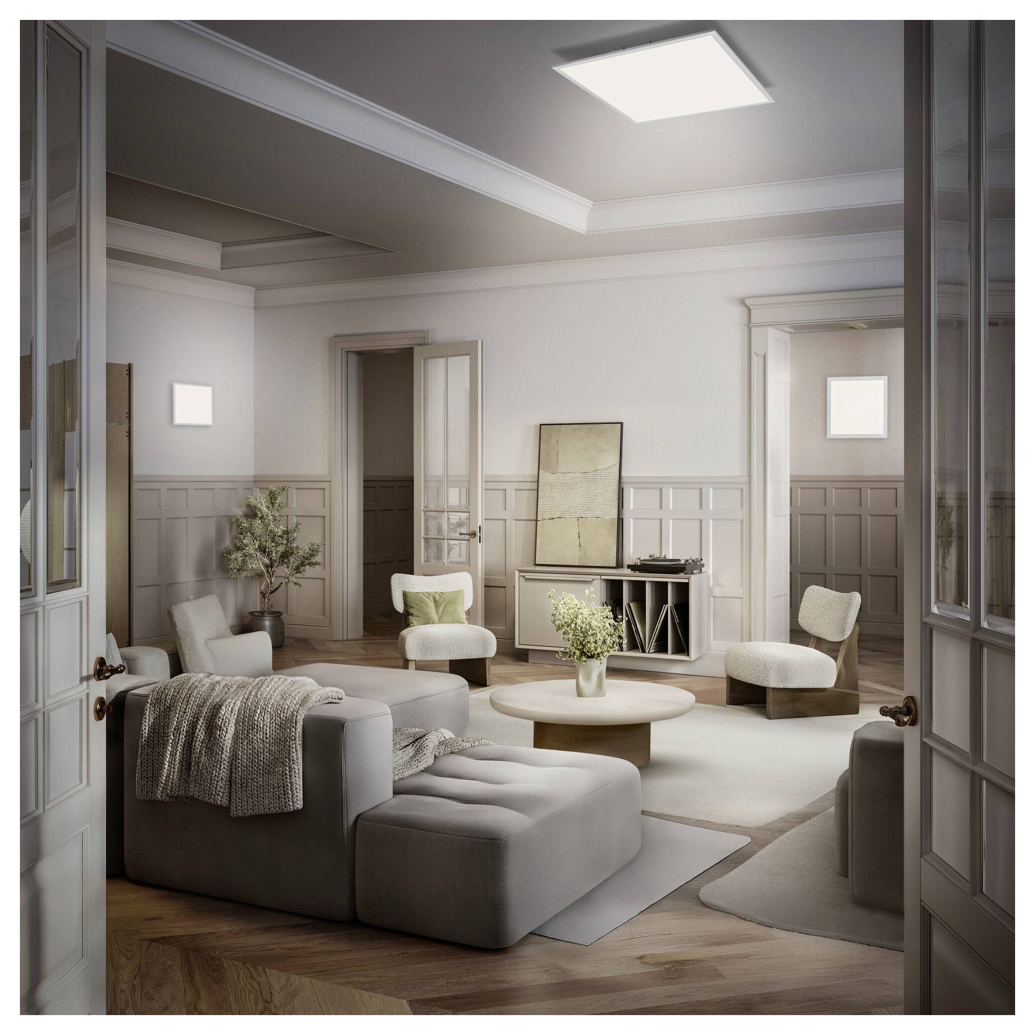 Elegantes Wohnzimmer mit neutralen Sitzmöbeln, rundem Couchtisch, Kunstwerken und Oberlicht, gesehen durch offene Doppeltüren.