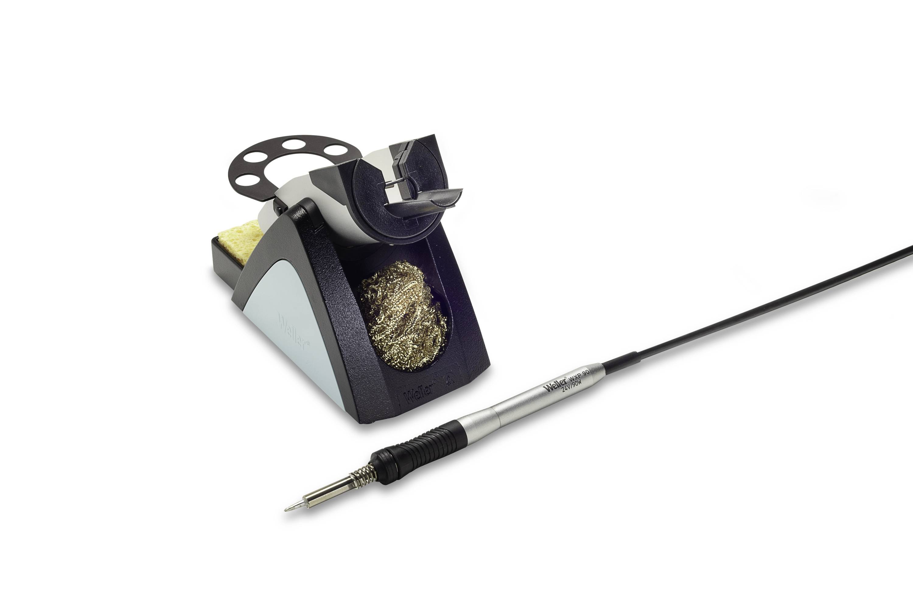 Electric soldering iron beside a stand with sponge and brass wool tip cleaner on a white background.