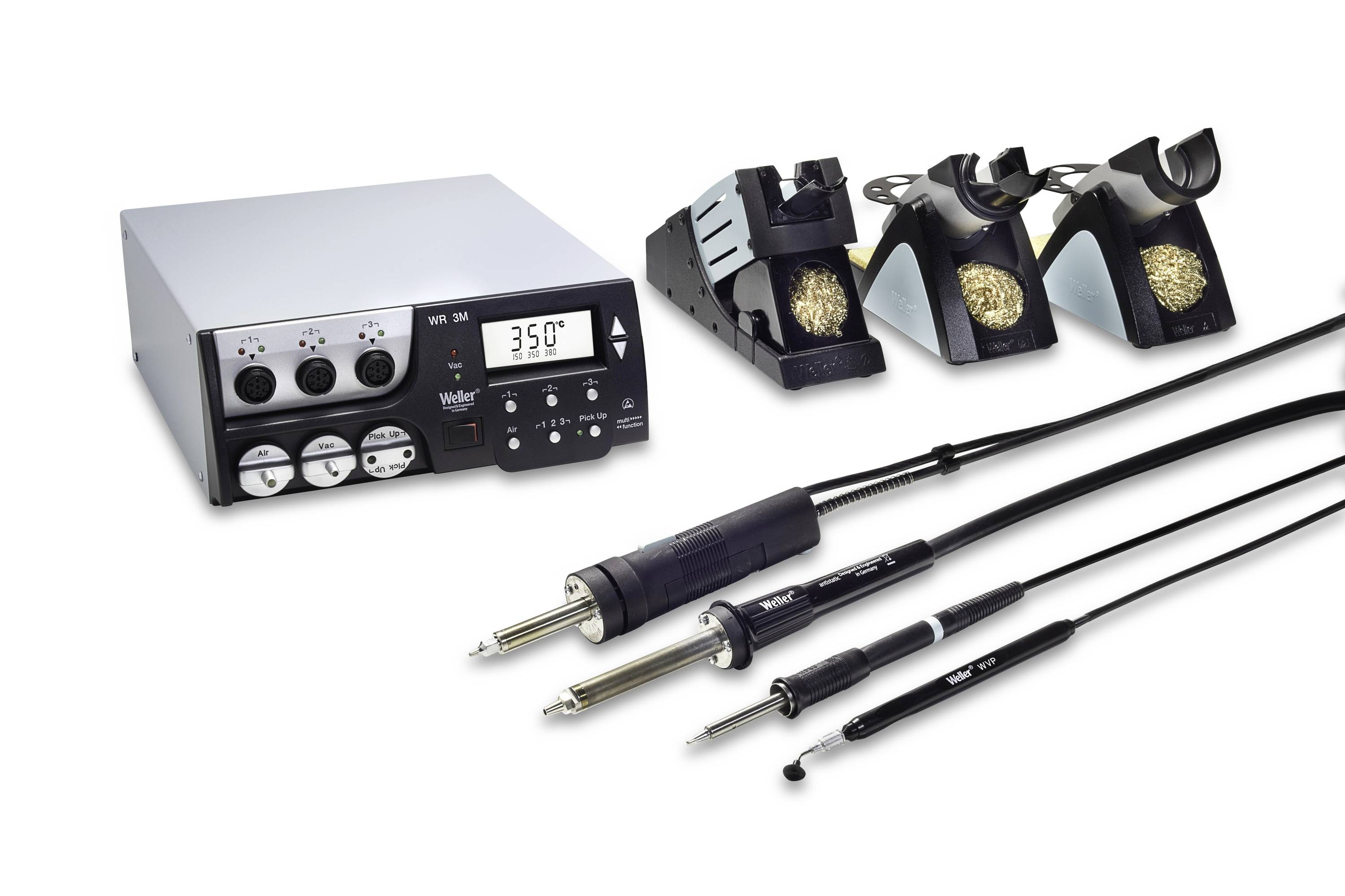 Soldering station with digital temperature display, three iron holders with brass cleaning pads, and four soldering irons on a white background.