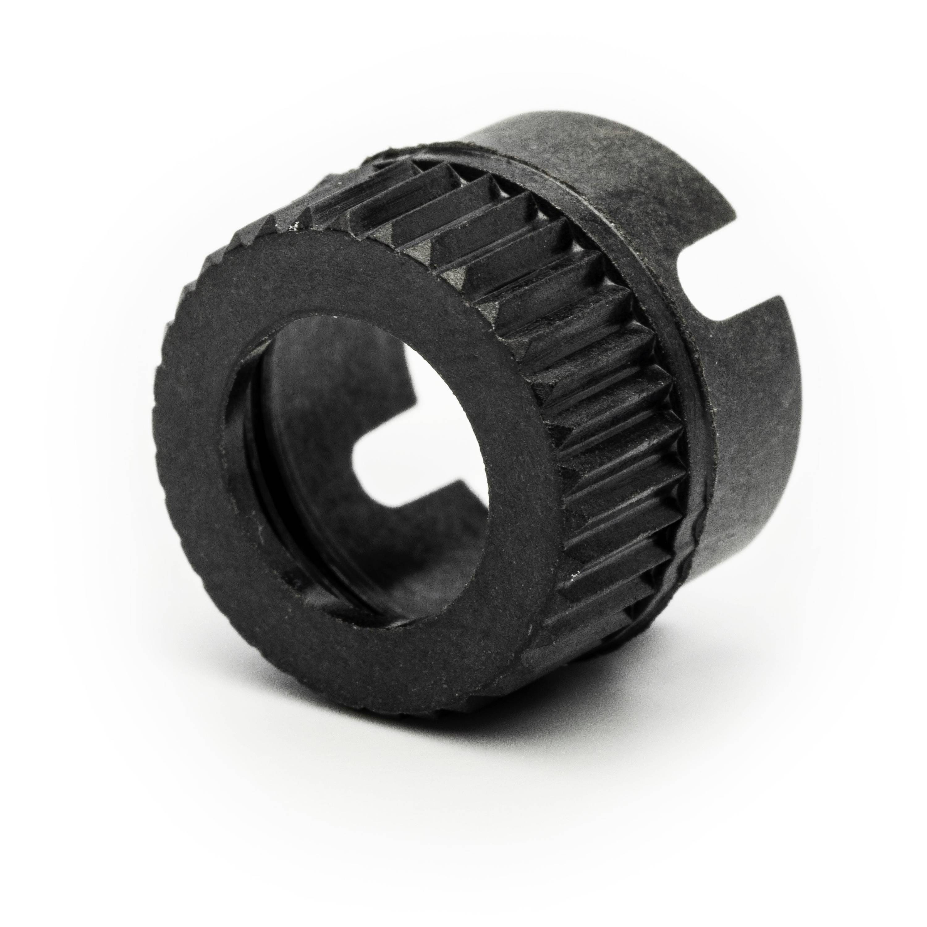 Black plastic cylindrical mechanical bushing with ridged outer edge and keyway cutouts, shown on a white background.