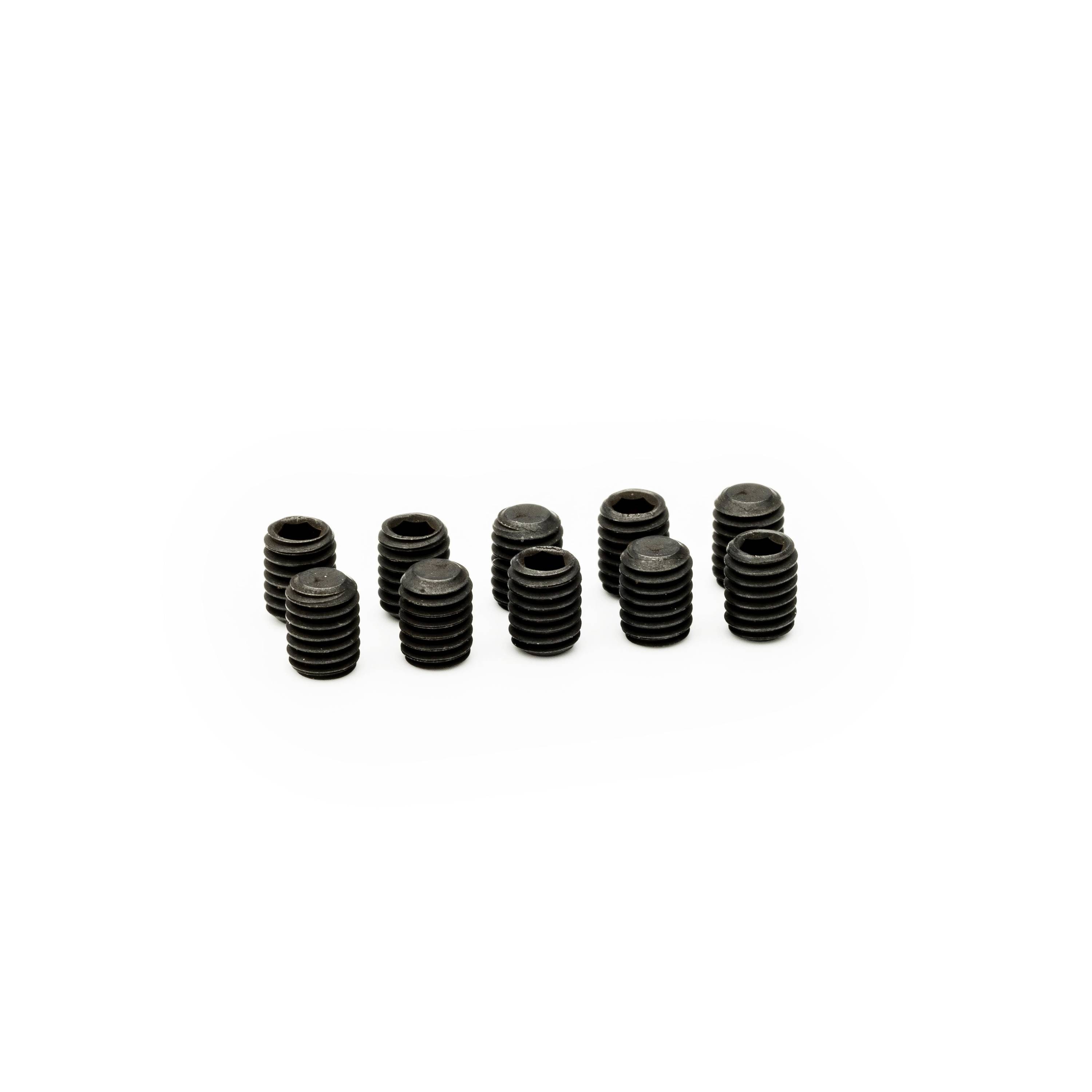 Several small black threaded metal inserts or set screws arranged in a cluster on a white background.