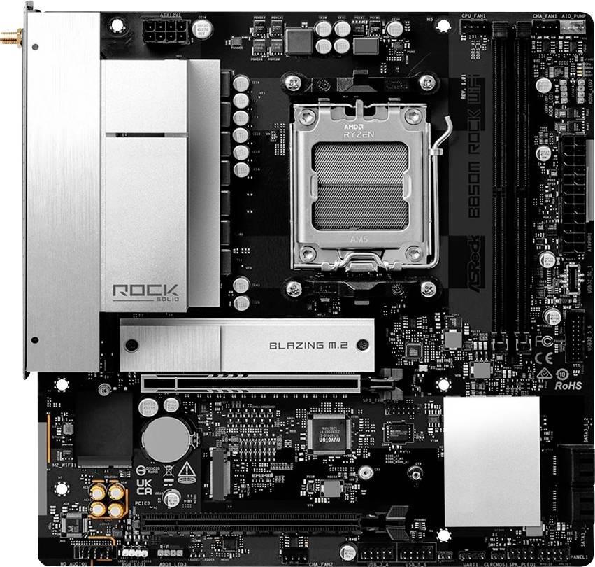 Draufsicht auf ein ASRock-Motherboard mit installiertem AMD Ryzen-Prozessor, das silberne Kühlkörper und eine M.2-Steckplatzabdeckung zeigt.