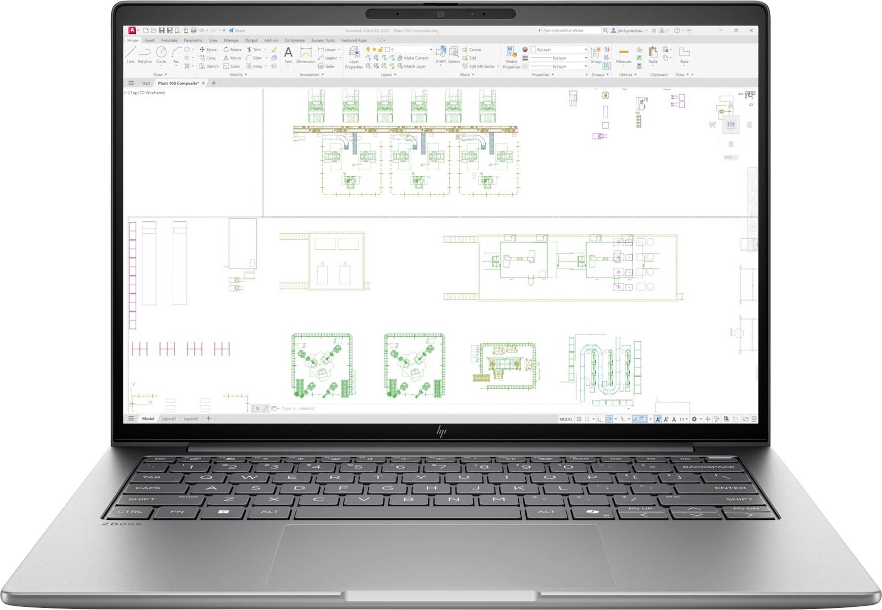 Laptop zeigt eine CAD-/Grundrisszeichnung mit mehreren Raumlayouts und farbigen architektonischen Symbolen auf einer Designfläche.