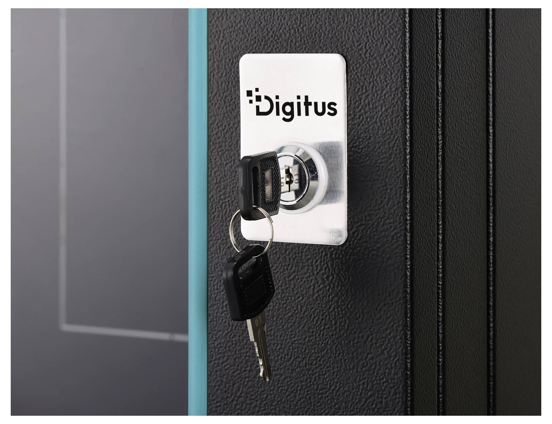 Nahaufnahme eines Digitus-Schlosses an einer schwarzen Schranktür mit eingestecktem Schlüssel und einem weiteren Schlüssel, der am Schlüsselbund hängt.