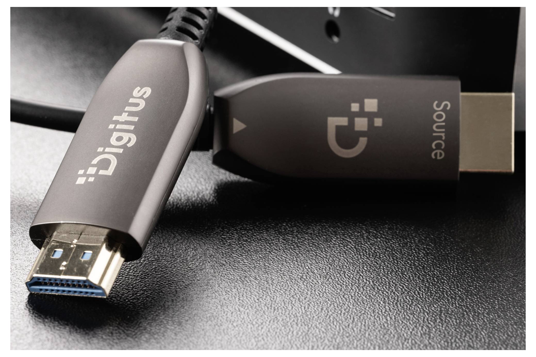 Nahaufnahme von zwei Digitus USB-C-Kabeln/Adaptern auf einer dunklen Oberfläche, eines mit der Bezeichnung „Quelle