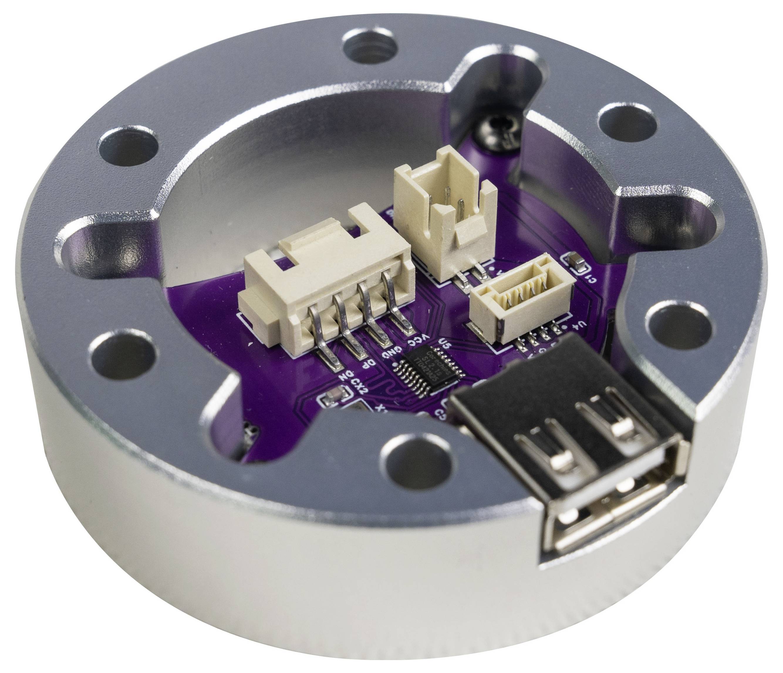Nahaufnahme einer kleinen violetten Leiterplatte, die in einem runden Metallgehäuse montiert ist, mit mehreren weißen Steckverbindern und einem USB-Anschluss.