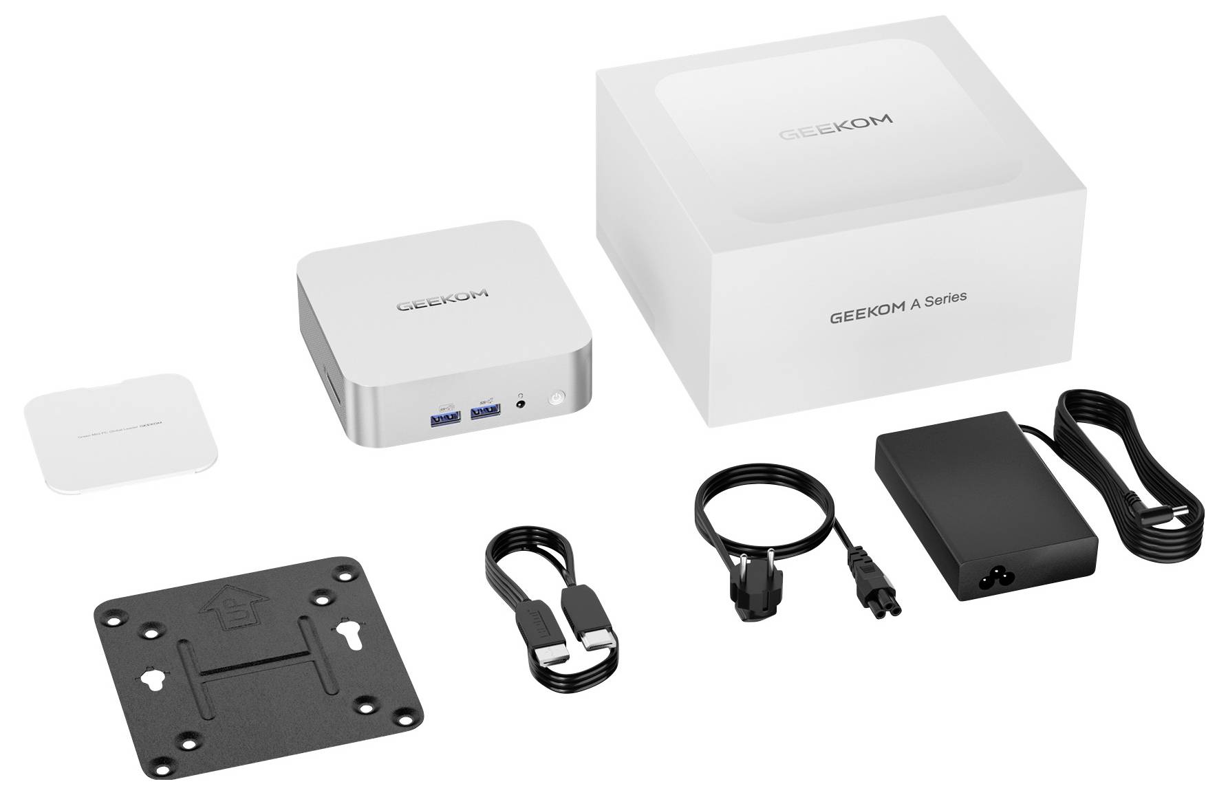 Geekom Mini-PC-Paketinhalt aufgelegt: kompakter Computer, Netzteil und Kabel, VESA-Halterung, HDMI-Kabel und weiße Zubehörbox neben der Produktverpackung.