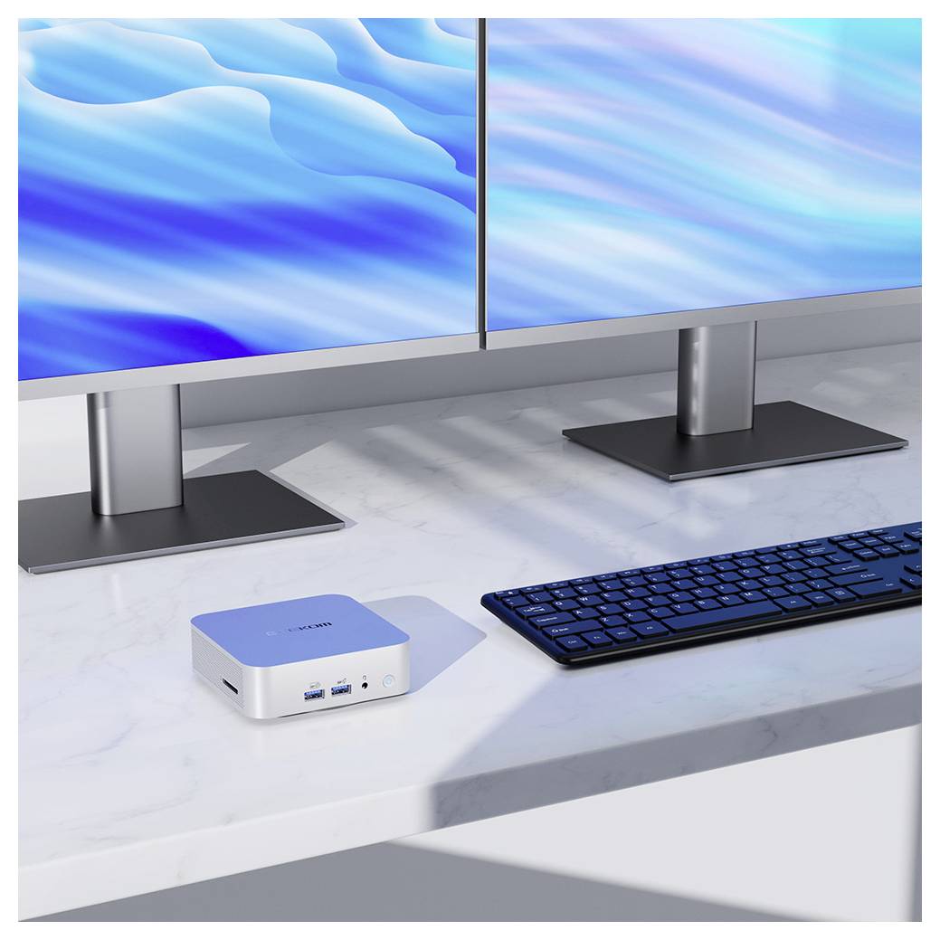 Dual-Monitor-Desktop-Setup mit einem kompakten Mini-PC, Tastatur und blauen abstrakten Hintergrundbildern auf einem Marmortisch.