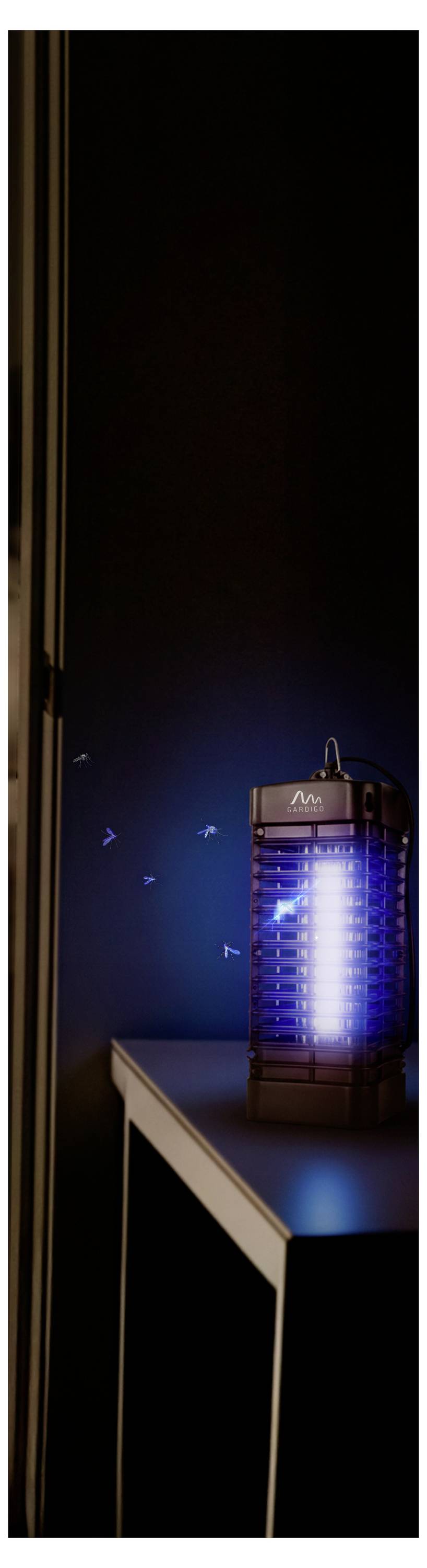 Eine kleine leuchtende Laterne oder tragbare Lampe sitzt auf der Ecke eines Tisches in einem dunklen Zimmer.