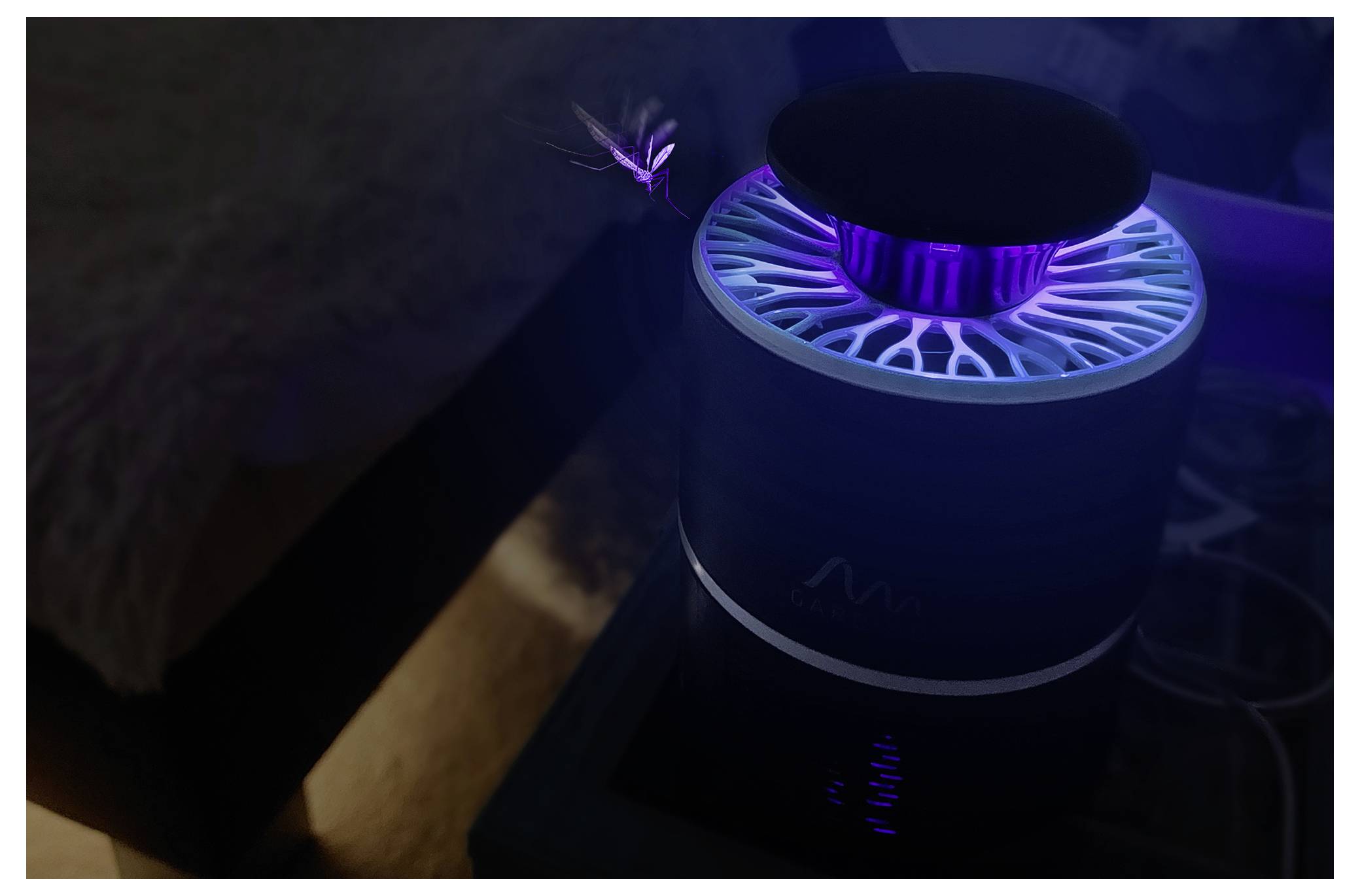 Ein leuchtendes purpur-blaues zylindrisches Gerät mit einer kreisförmigen Oberseite sitzt auf einer Oberfläche neben einem Bett in einem schwach beleuchteten Raum, mit einem kleinen Licht darüber.