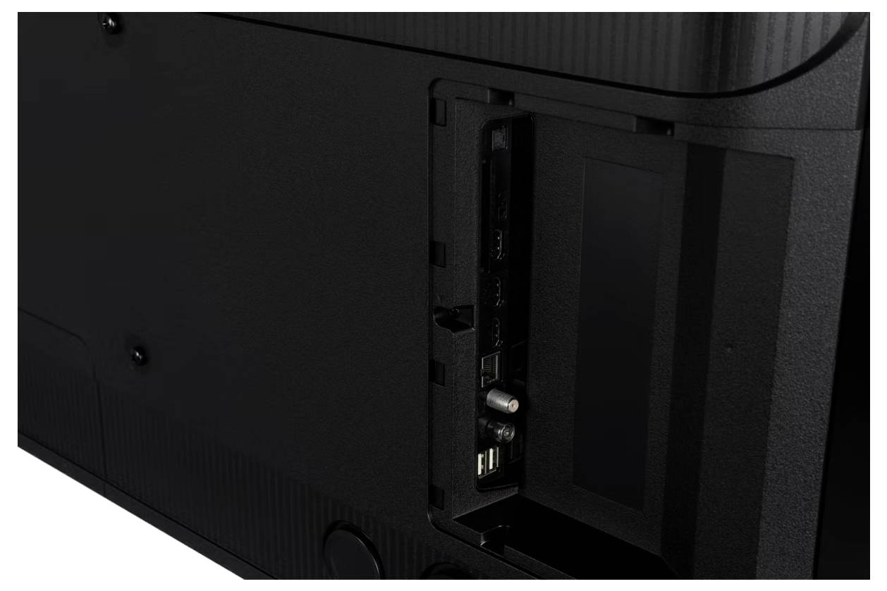 Rückansicht eines Fernsehers mit versenkten Anschlüssen und Eingabeplatte, einschließlich HDMI- und USB-Anschlüsse, in einem schwarzen Gehäuse.