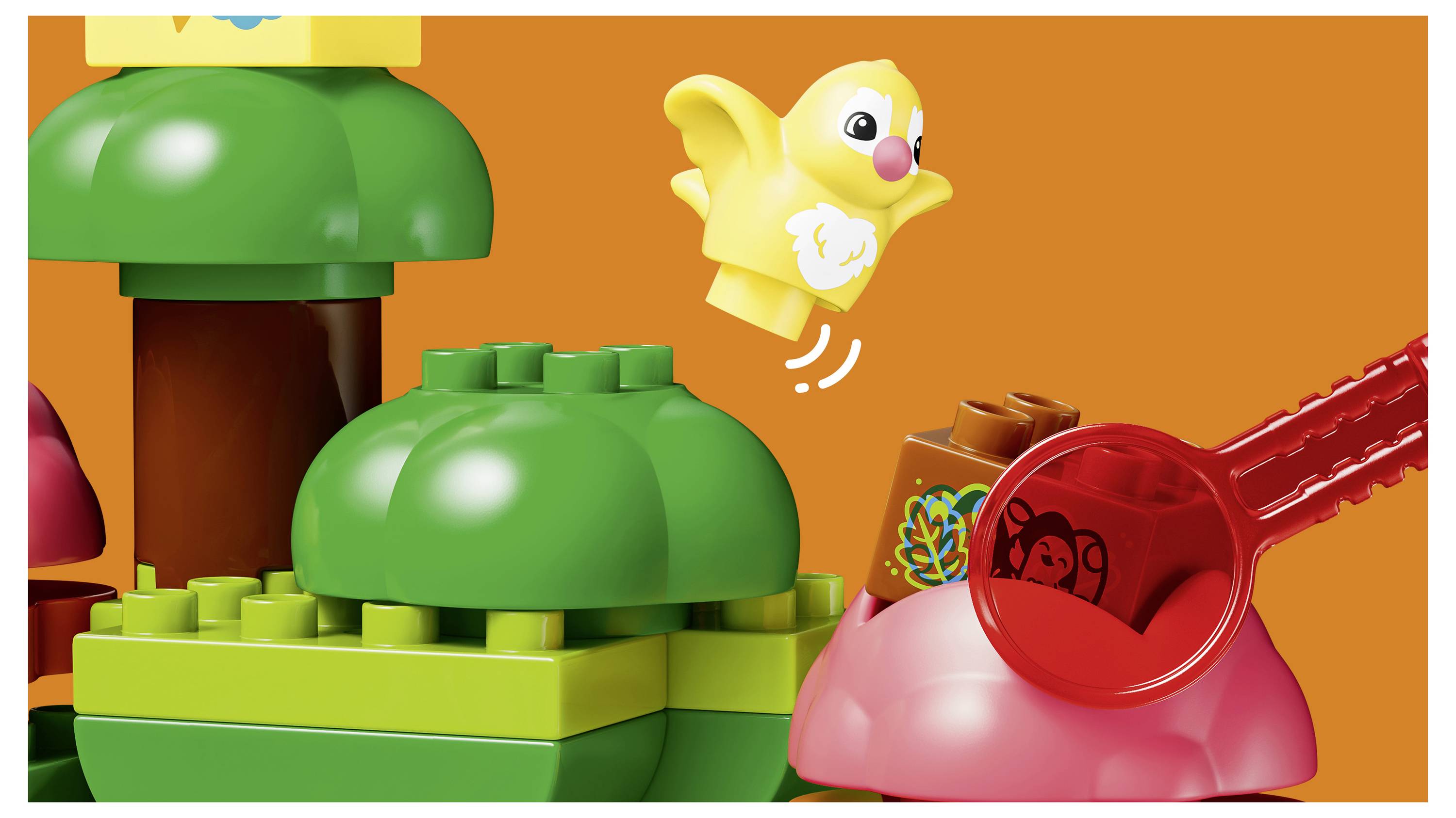 LEGO-ähnliche Szene mit einem gelben Vogel, der über bunten Pflanzen- und Pilzteilen auf orangefarbenem Hintergrund fliegt