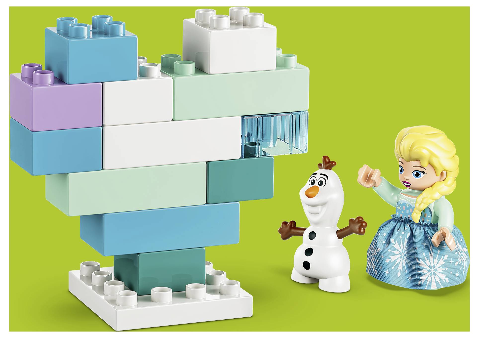 Ein LEGO-ähnliches Spielzeugmodell eines türkisfarbenen und weißen Herzens auf einem Sockel, mit Olaf- und Elsa-Figuren daneben vor grünem Hintergrund.