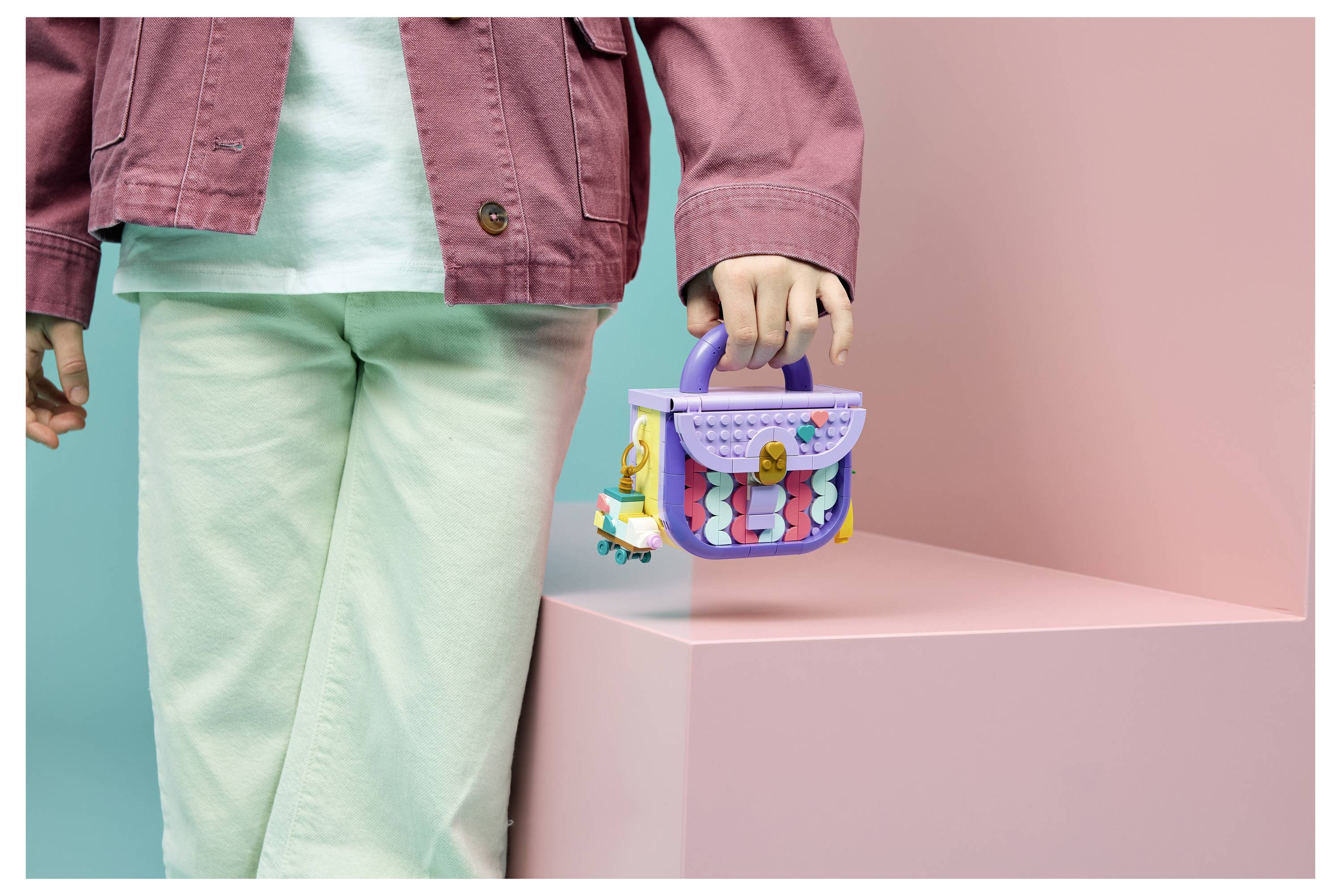Kinder sitzen um einen Tisch herum und montieren farbenfrohe Bastelmaterialien und Perlen, während sie zwei Tablets benutzen, was auf eine gemeinsame kreative Aktivität oder ein Spiel hindeutet.