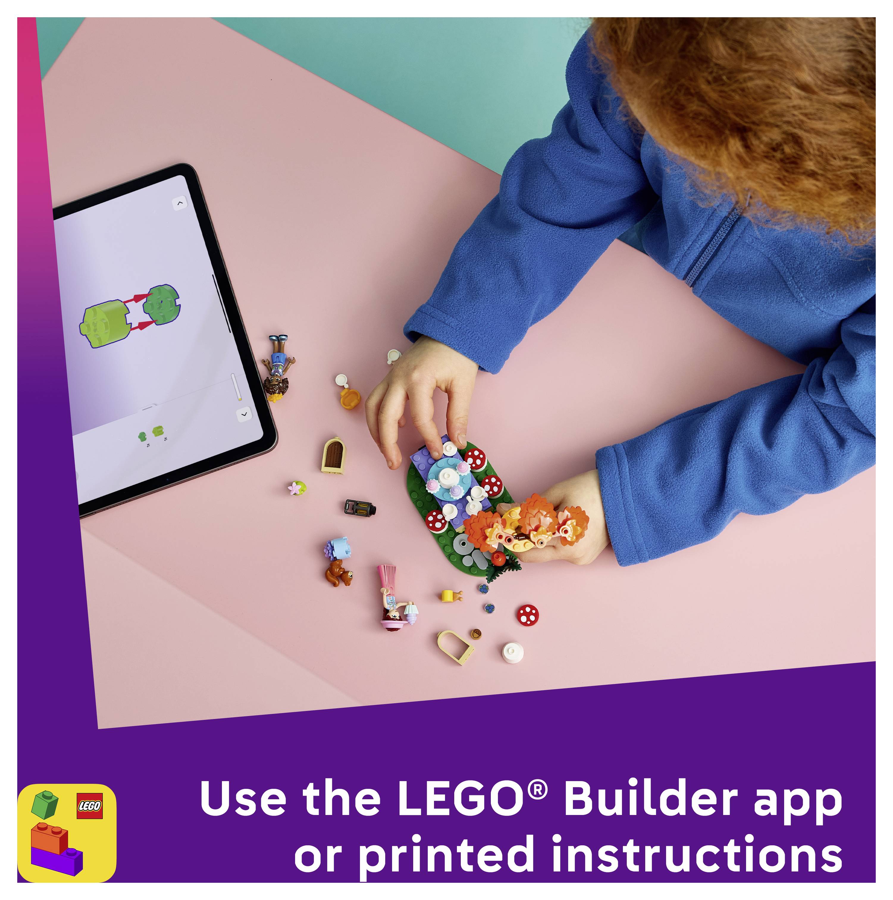 Kind im blauen Pullover baut ein LEGO-Modell auf einem rosa Tisch neben einem Tablet, das Anleitung zeigt, mit Text: „Nutzen Sie die LEGO Builder-App oder gedruckte Anleitung