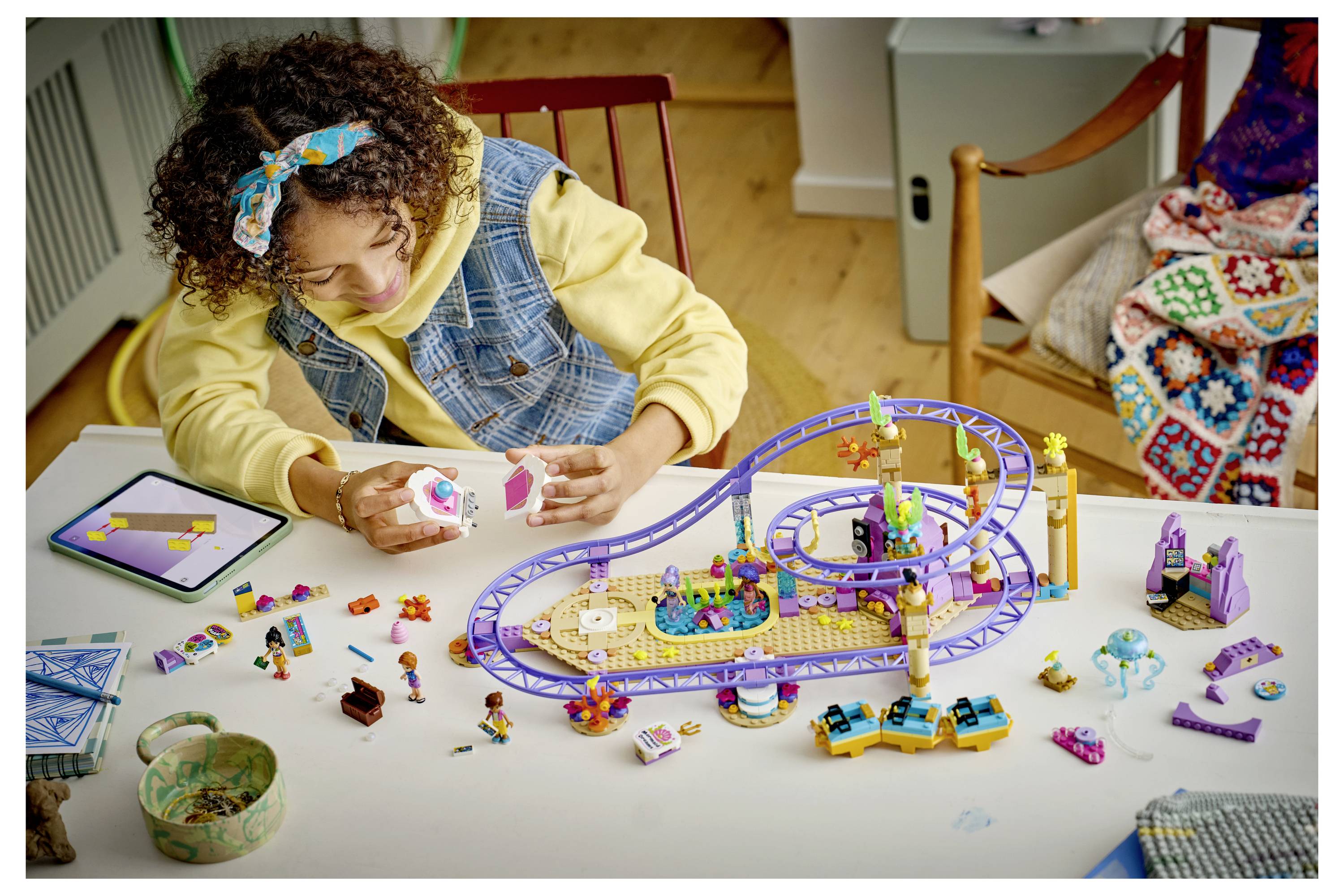 Kind spielt mit einem bunten blütenthematischen Baukasten, mit Altersangabe 7+ und 321 Teilen.