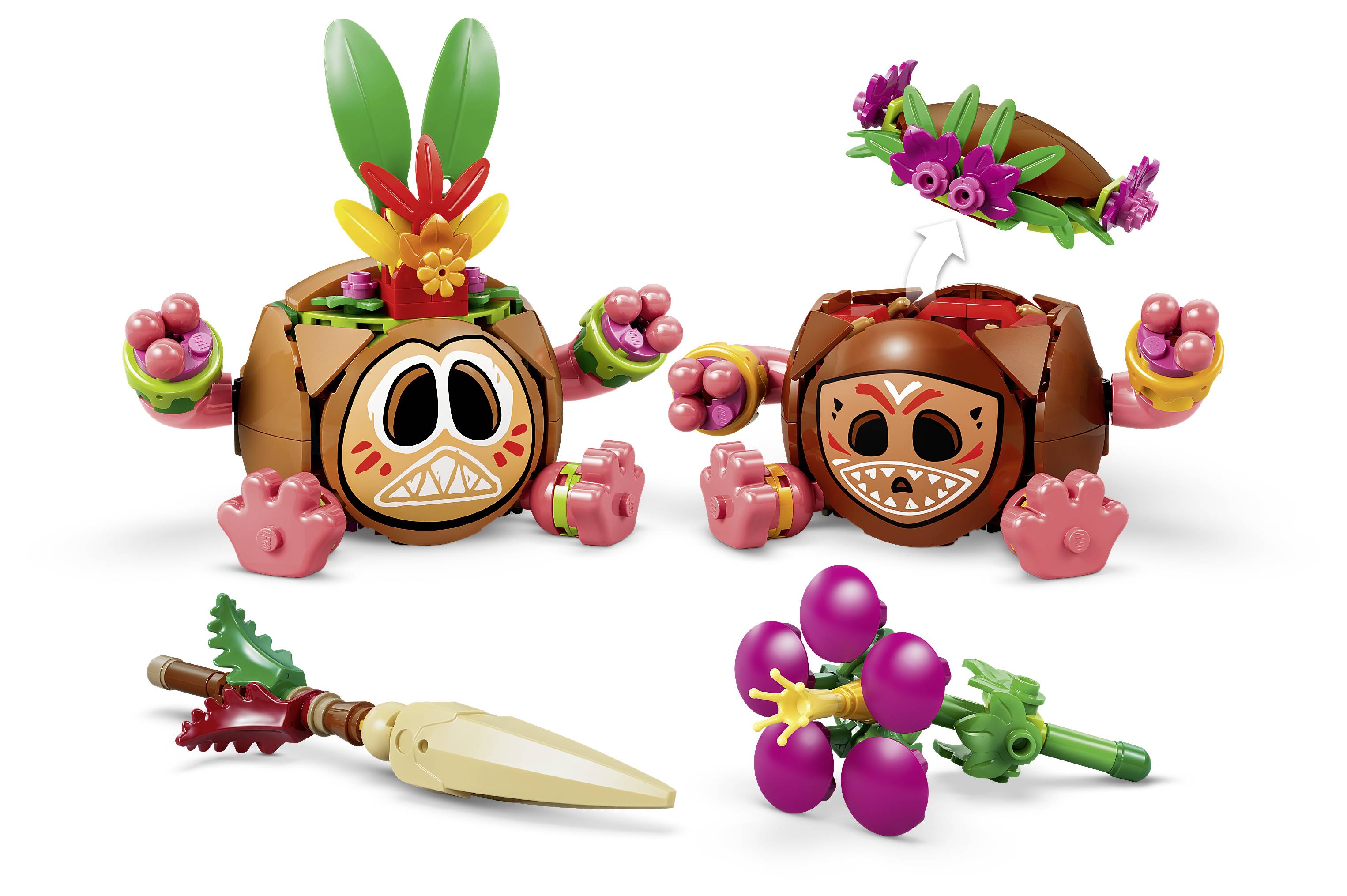 Zwei stilisierte Holztotem-Figuren mit geschnitzten Gesichtern und floralen Verzierungen, gezeigt mit zwei kleinen Spielzeugwaffen oder Zubehörteilen auf weißem Hintergrund.