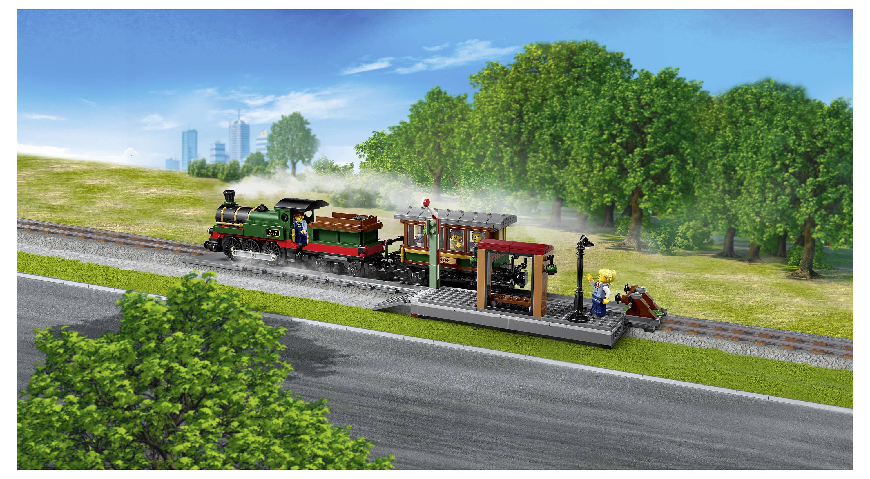 Dampflokomotive an einem kleinen Bahnhof auf dem Land mit Arbeitern neben dem Bahnsteig, die sich durch eine grüne Landschaftsszenerie unter einem hellen blauen Himmel bewegt.