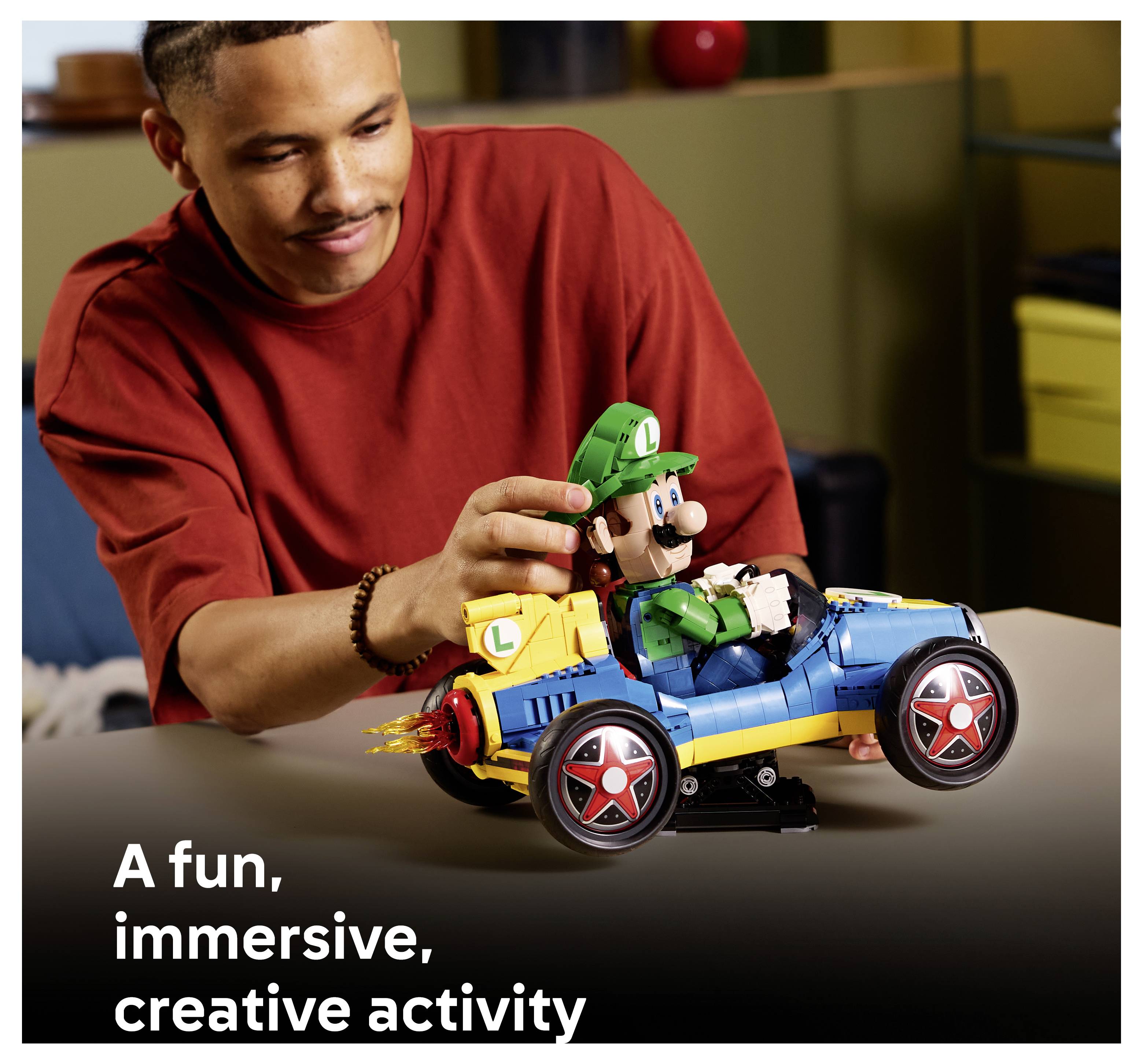 Ein Mann baut ein LEGO-Luigi- und blaues Kart-Spielzeug zusammen; die Bildunterschrift lautet „Eine unterhaltsame, immersive, kreative Aktivität