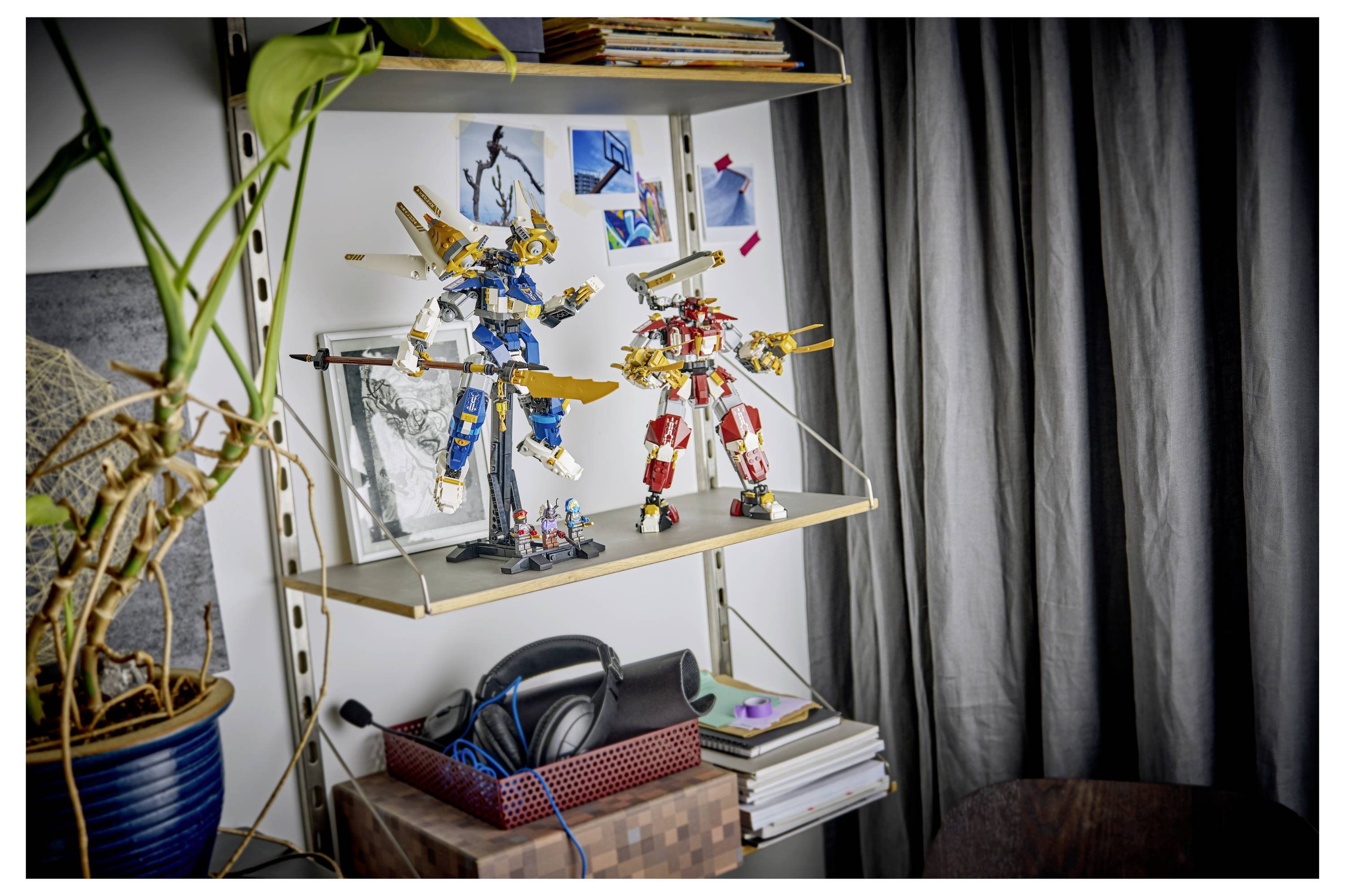 Regalbeschreibung mit zwei farbenfrohen Roboter-/Mecha-Modellfiguren auf dem mittleren Regal, neben gerahmtem Artwork, Kopfhörern, Büchern und einer Topfpflanze.