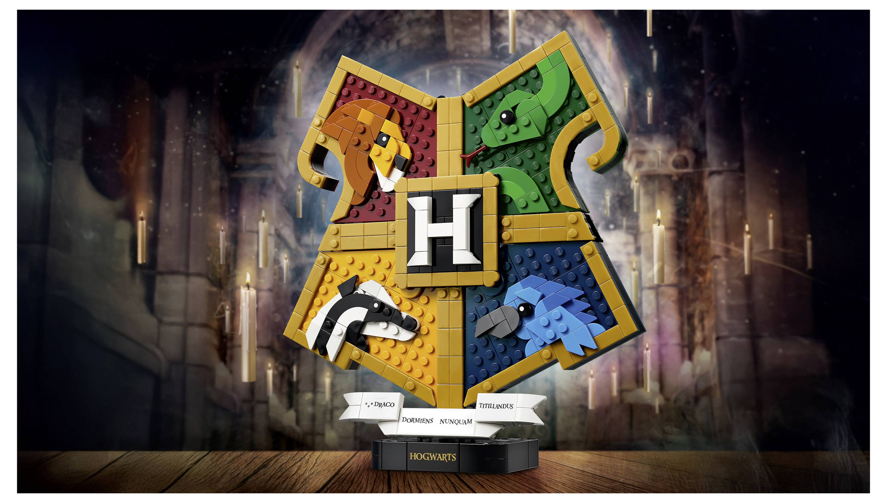 LEGO-Wappenschild Hogwarts mit vier Hauswappen-Tieren – Löwe, Schlange, Dachs und Adler – um ein zentrales 'H' auf einem Ständer.