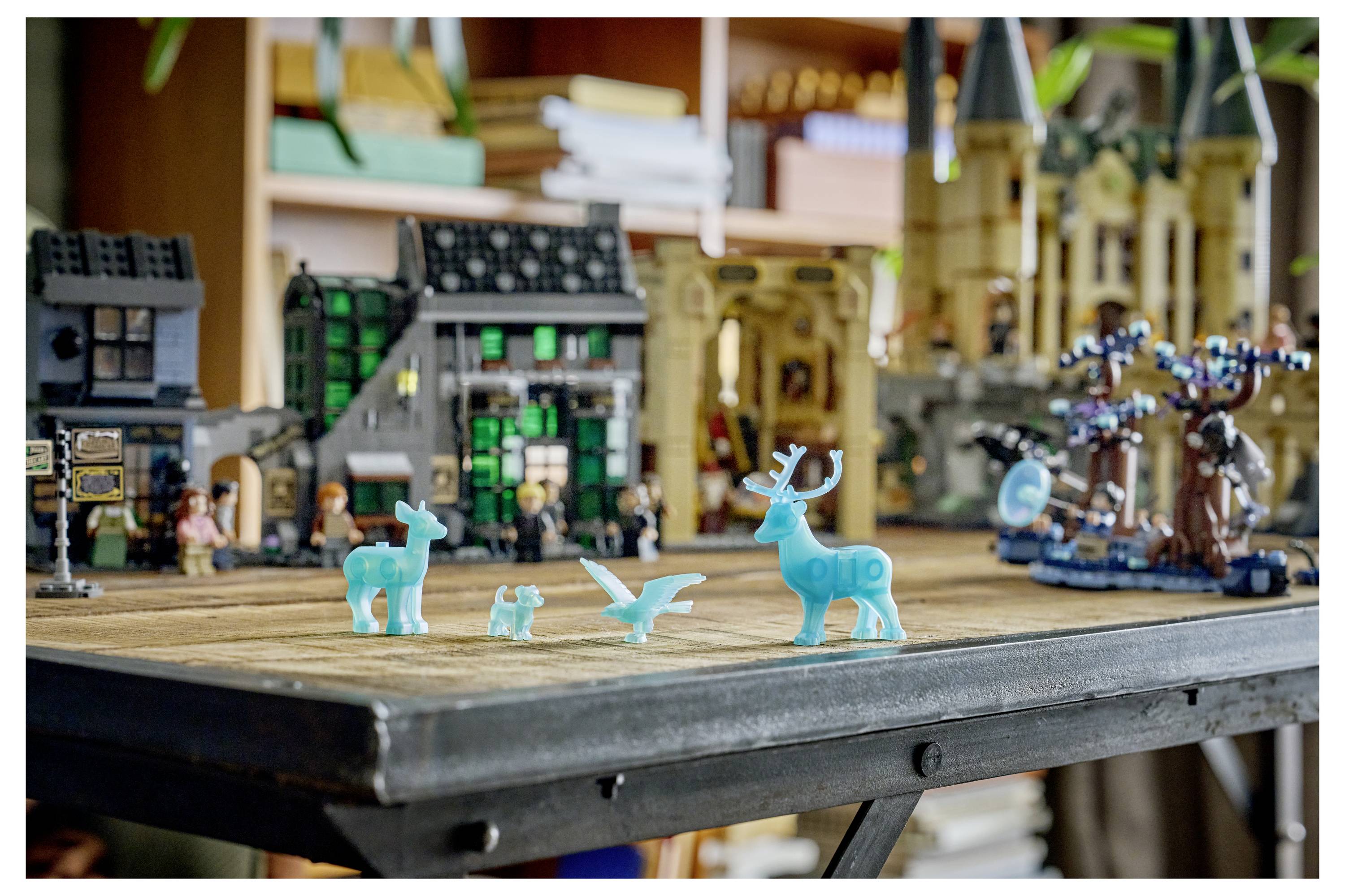 Spielzeugkitze und Vögel auf einer Tischplatten-Diorama, mit LEGO-ähnlichen Dorf- und Schlossmodellen im Hintergrund.