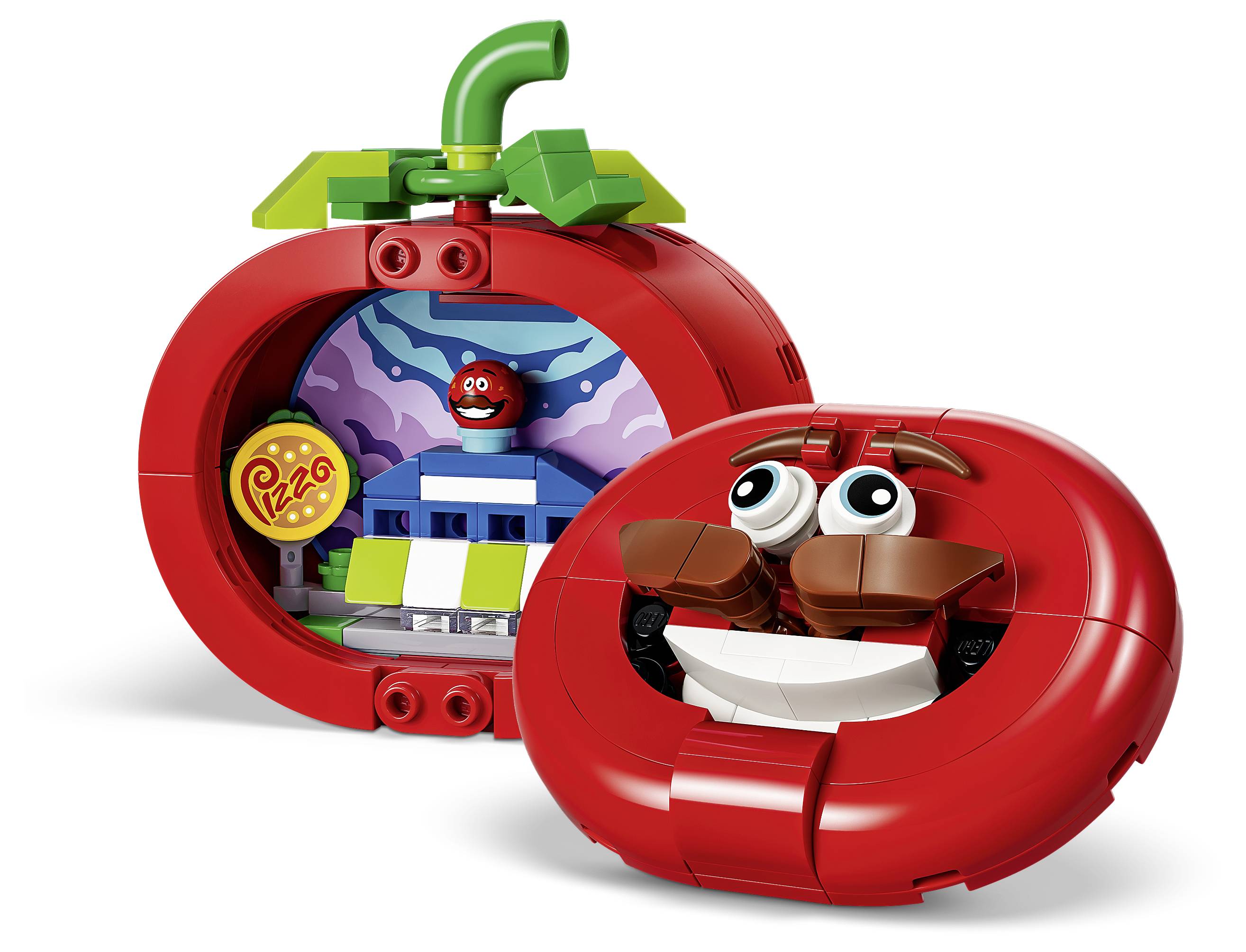 LEGO-ähnliches rot geformtes Tomaten-Spielzeug mit lächelndem Gesicht und geöffnetem Spielset mit einer Pizzaszene und einer kleinen Figur darin.