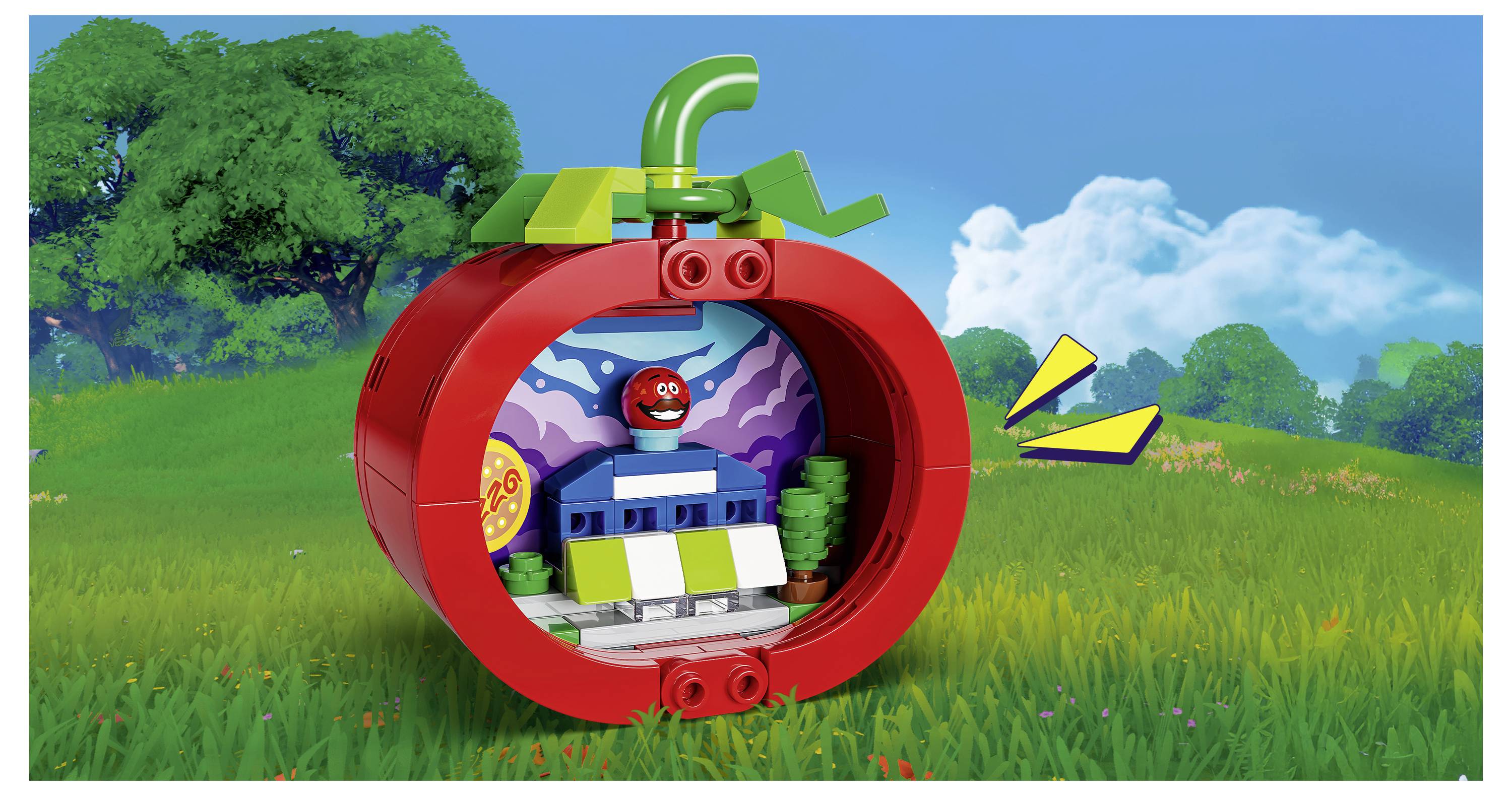 LEGO-ähnliches rotes apfelförmiges Spielset mit einer kleinen Figur innen, angesiedelt auf einer grünen Wiese unter blauem Himmel