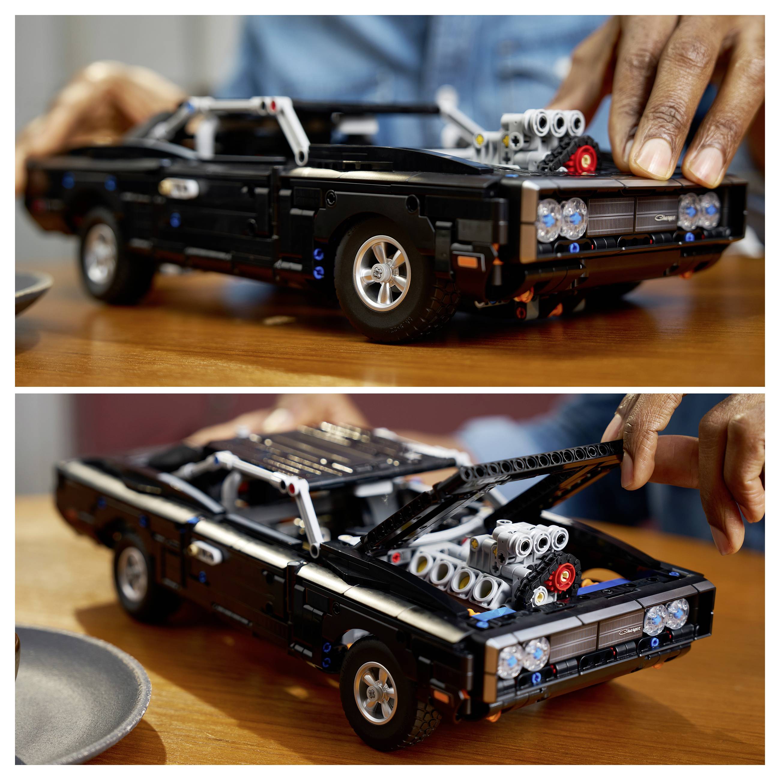 Eine Person öffnet die Motorhaube eines schwarzen LEGO-ähnlichen Sportwagenmodells auf einem Holztisch.