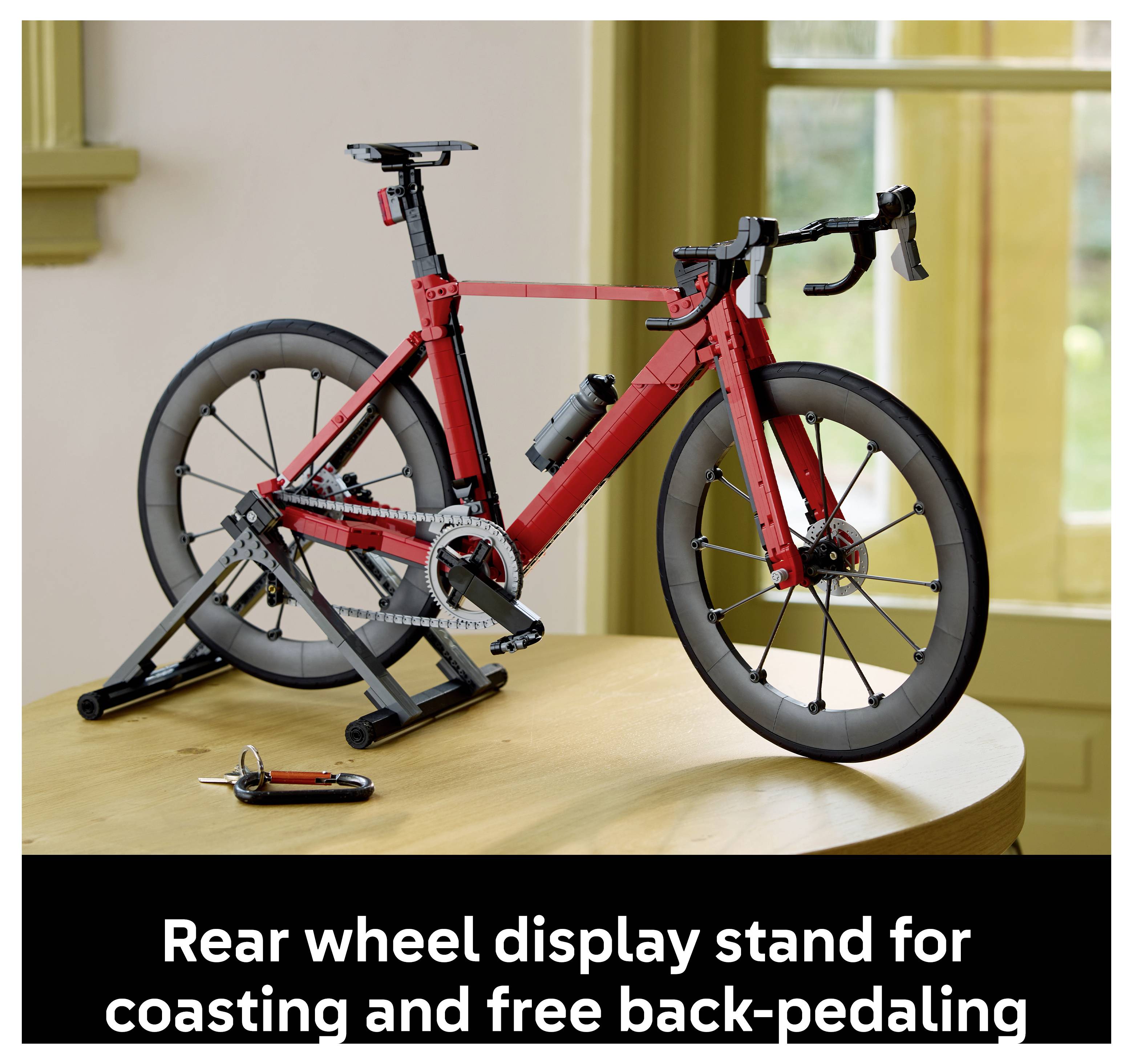 Rotes Rennrad auf einem Hinterrad-Ausstellungsständer, mit der Beschriftung „Hinterrad-Ausstellungsständer zum Freilauf und freien Rückwärtspedalieren