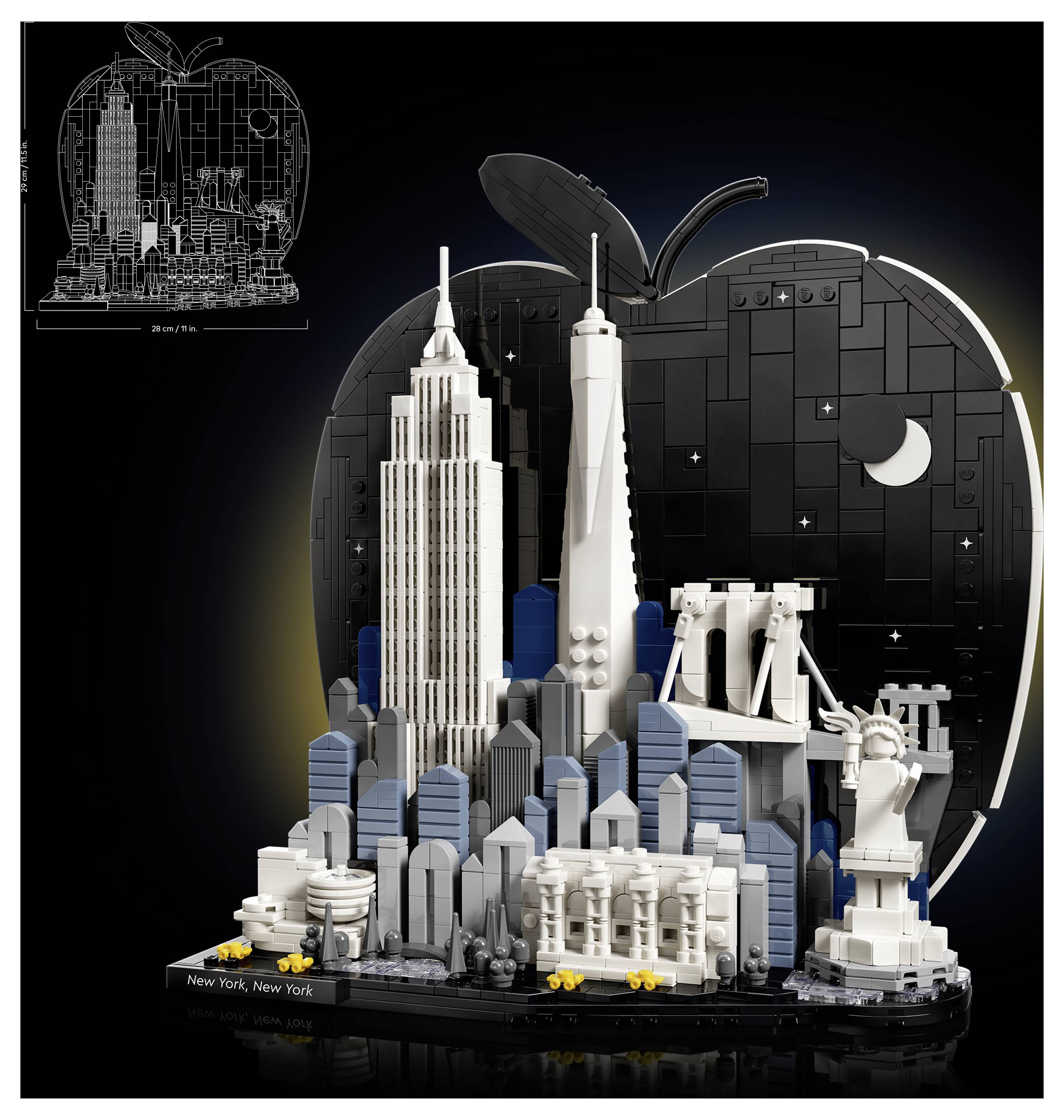 LEGO-ähnliches Modell der New Yorker Skyline mit dem Empire State Building, den World Trade Center Türmen, der Brooklyn Bridge und der Freiheitsstatue vor einem schwarzen apfelförmigen Hintergrund.