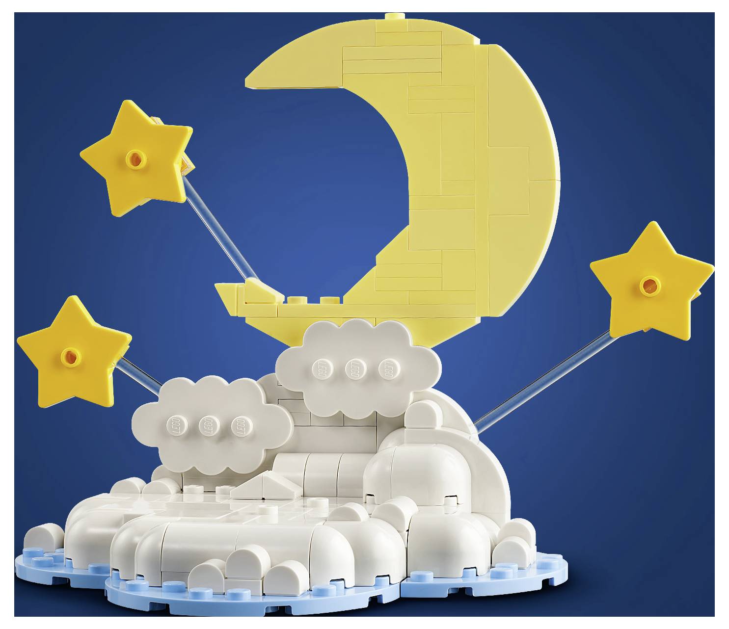 LEGO-ähnliches Modell einer Mondsichel auf Wolken mit drei Sternen vor blauem Hintergrund