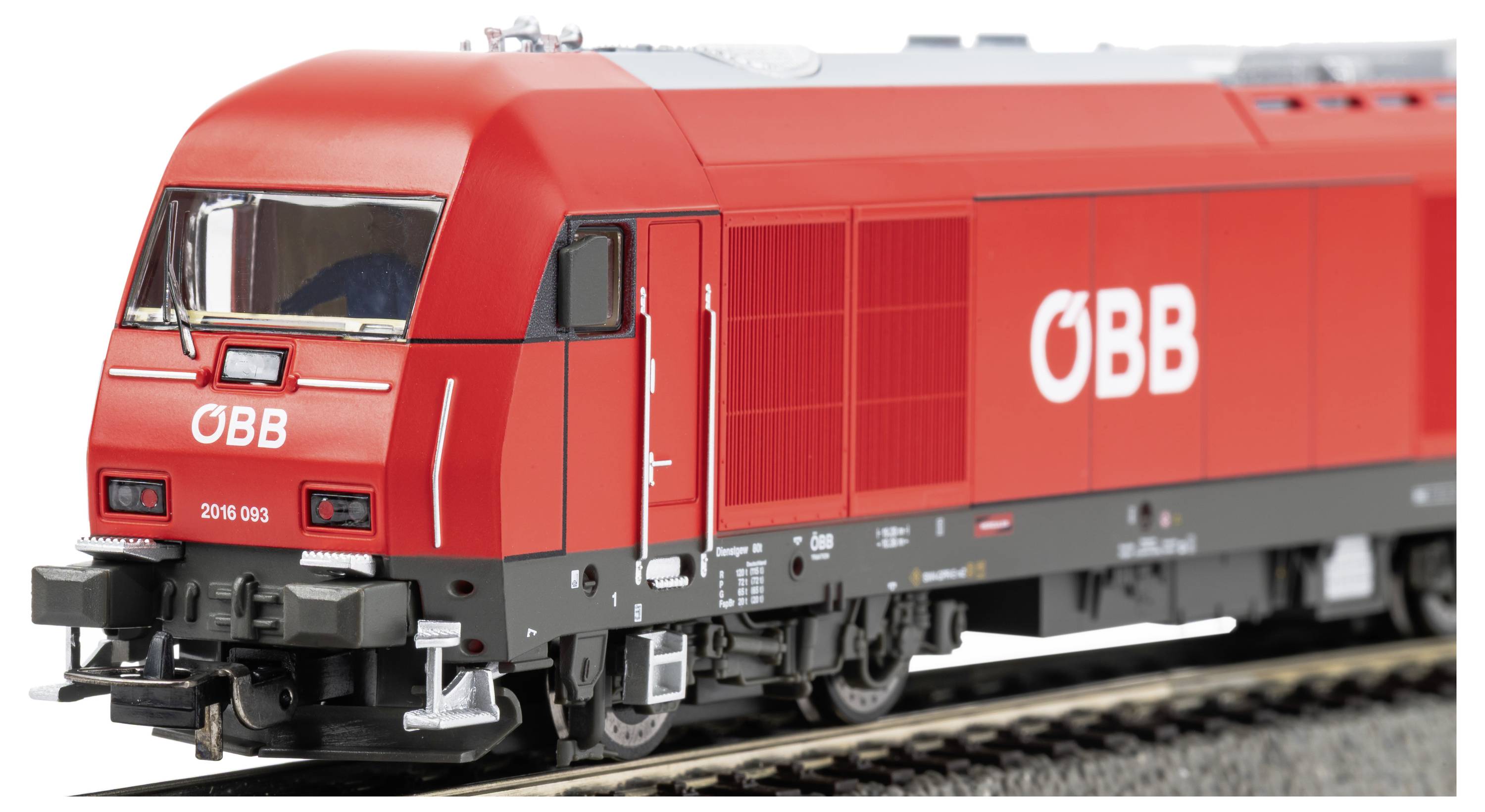 Rote ÖBB-Diesellokomotive im Modell auf Eisenbahngleis, in Seitenansicht dargestellt mit großem weißem ÖBB-Logo und Details der vorderen Führerstandskabine.