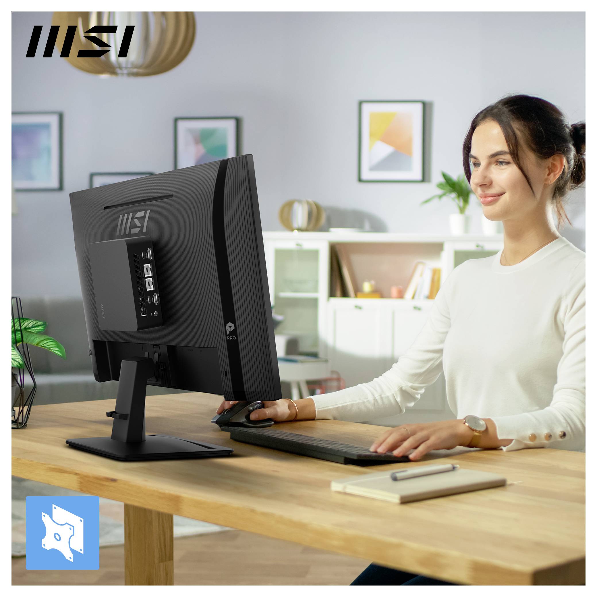 Frau, die einen MSI-Desktop-Computer und eine Maus an einem Holzschreibtisch in einem hellen Homeoffice benutzt.