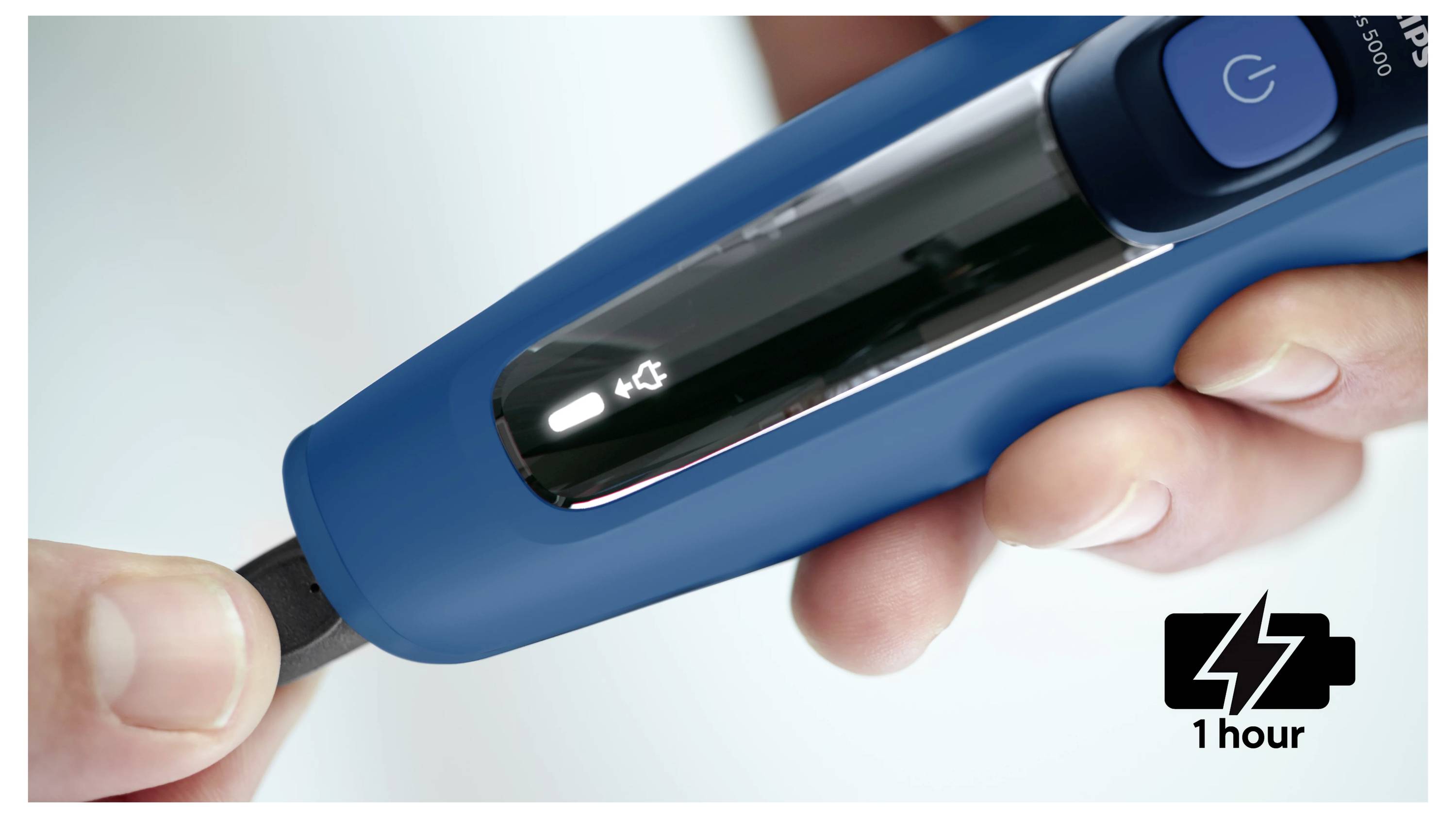 Eine Hand steckt ein Kabel in ein blaues tragbares Batterie-Ladegerät, wobei ein Batteriesymbol verbleibende „1 Stunde