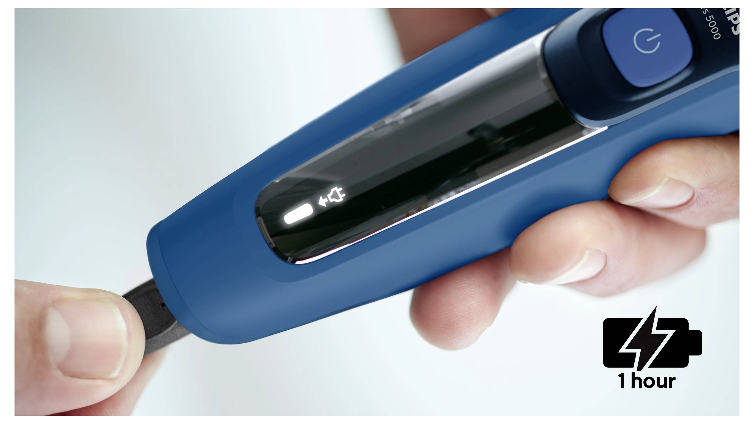 Hand, die ein blaues Blutzuckermessgerät mit eingesetztem Teststreifen hält, auf dem ein Batteriesymbol und eine Ladezenanzeige von 