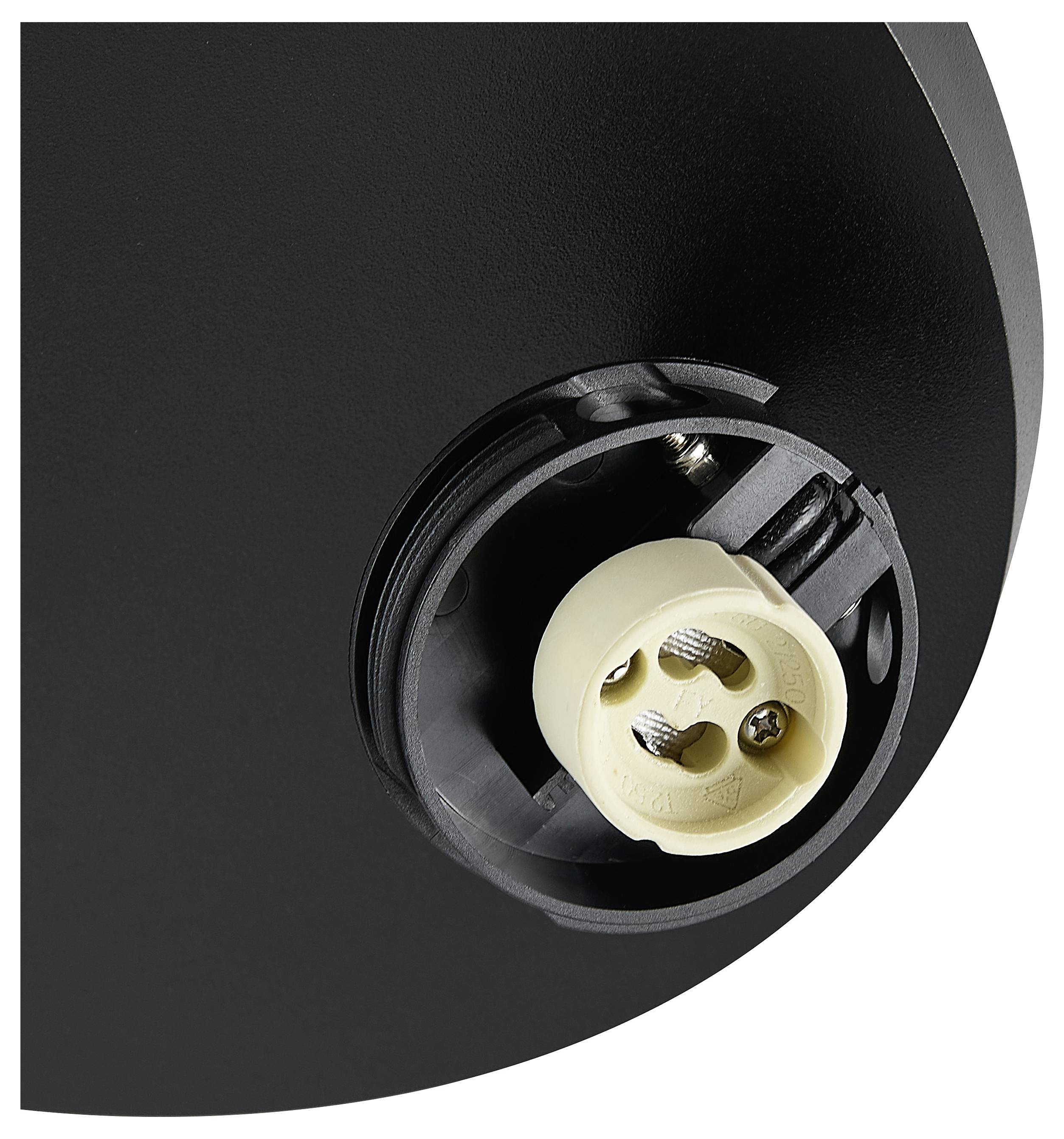 Nahaufnahme eines schwarzen kreisförmigen Geräts mit einer versenkten beigen Buchse oder einem Stecker mit Schraubklemmen.