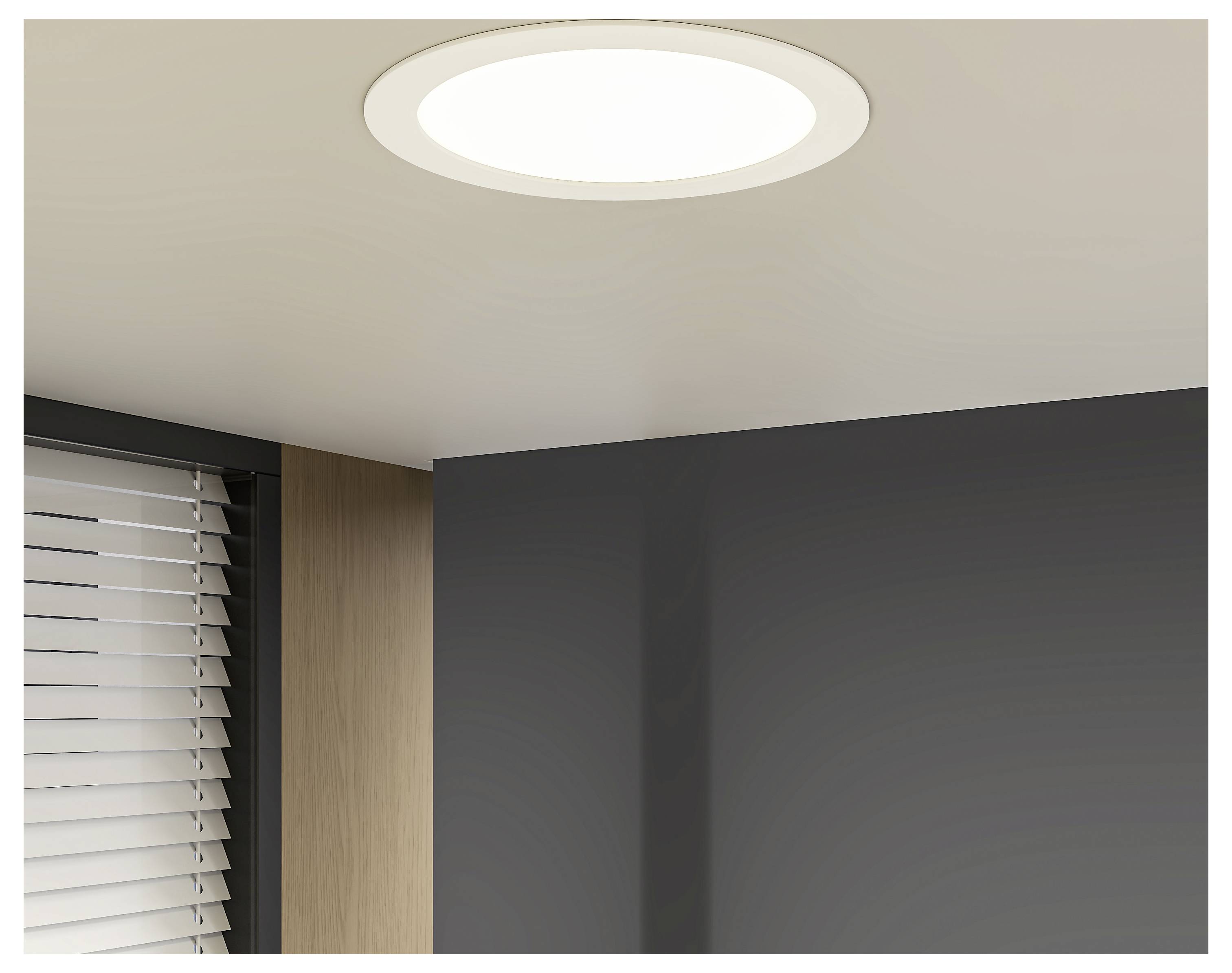 Deckenflächiges rundes Aufbau-Deckenleuchte in einer modernen Raumecke über einer dunkelgrauen Wand und Fensterrollos.