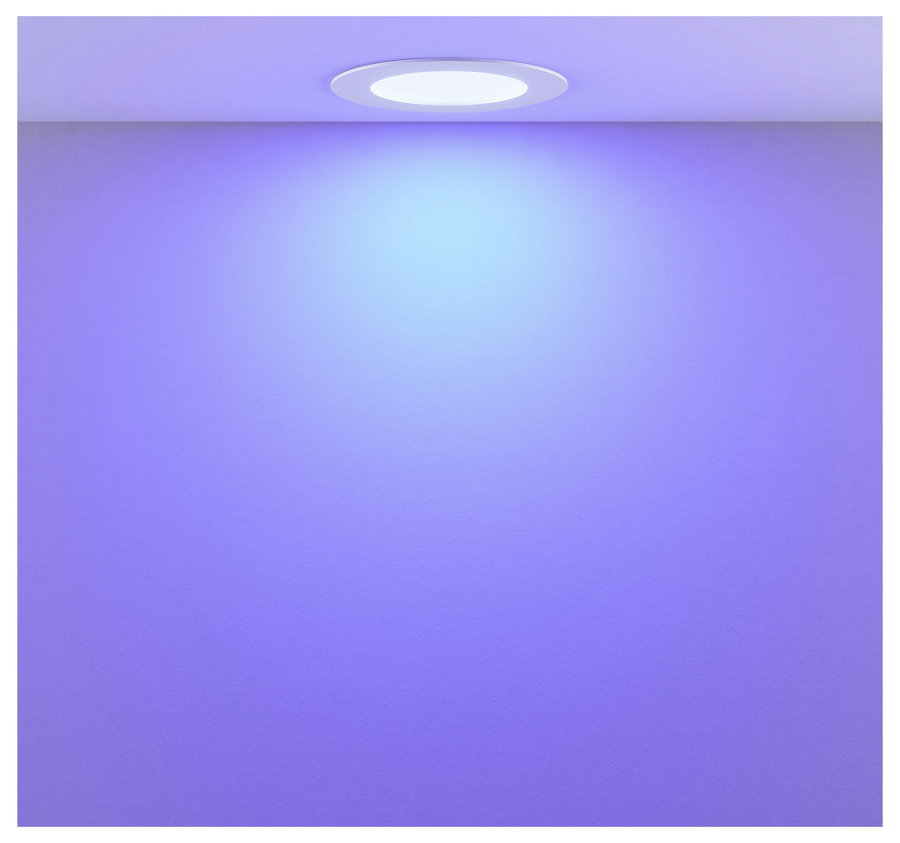 Violett beleuchtete Wand mit einem zentrierten Deckenspot, der einen blauen Glanz nach unten wirft.