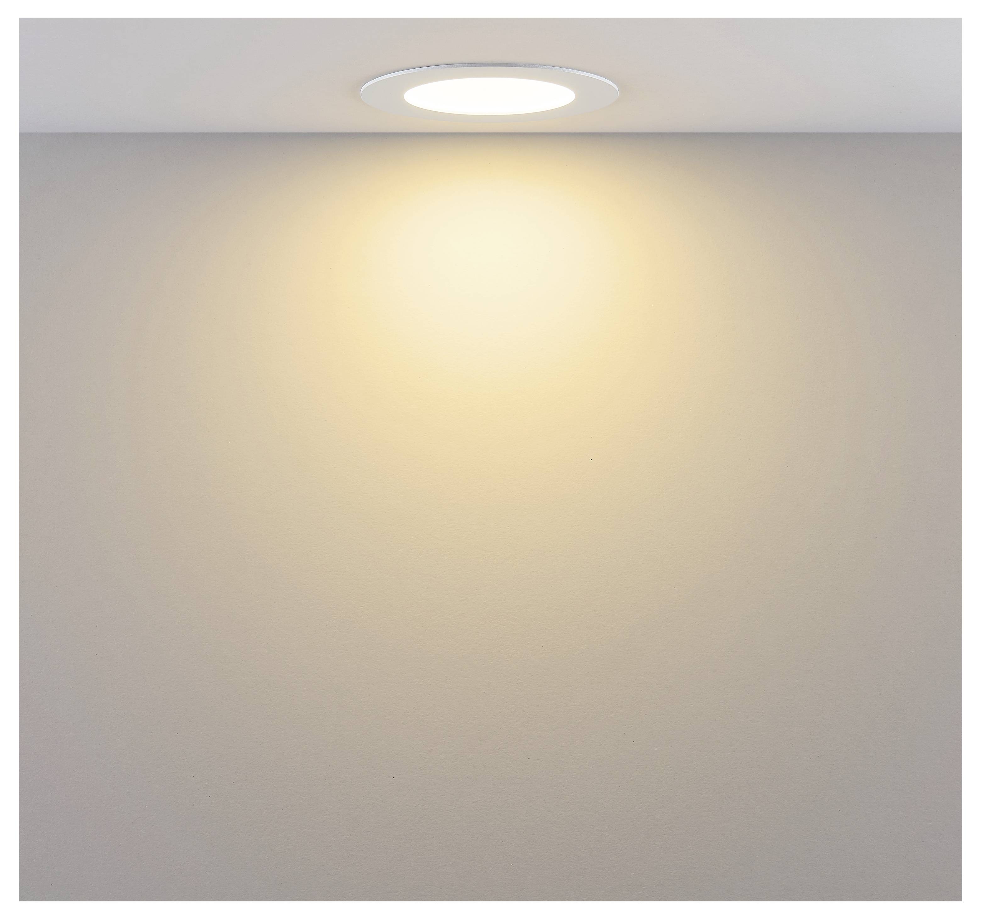 Deckeneinbauleuchte, die ein warmes Licht auf eine schlichte Wand wirft.