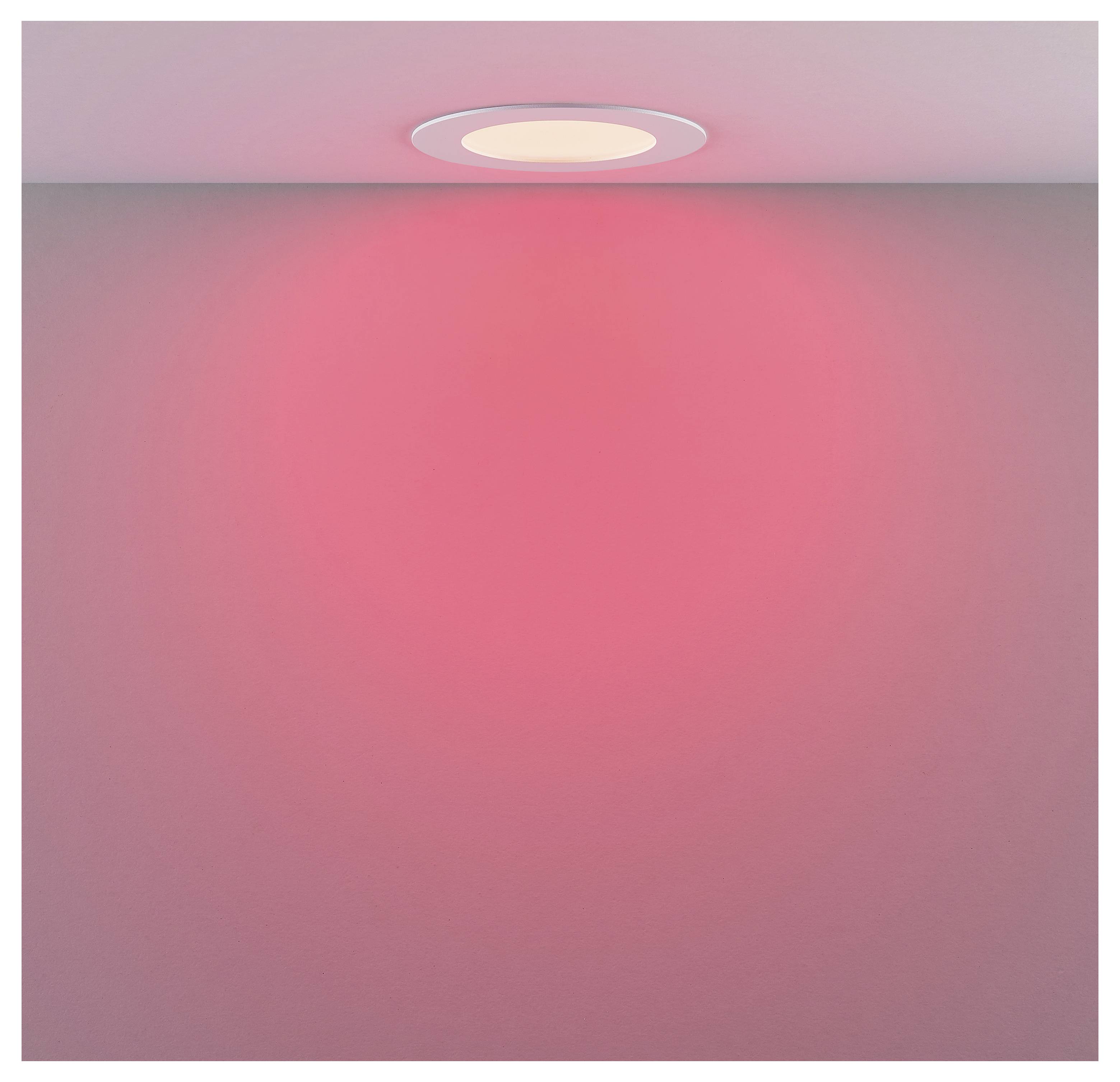 Deckenleuchte, die einen rosa Glanz auf eine glatte Wand wirft und einen weichen, kreisförmigen Lichtverlauf erzeugt.