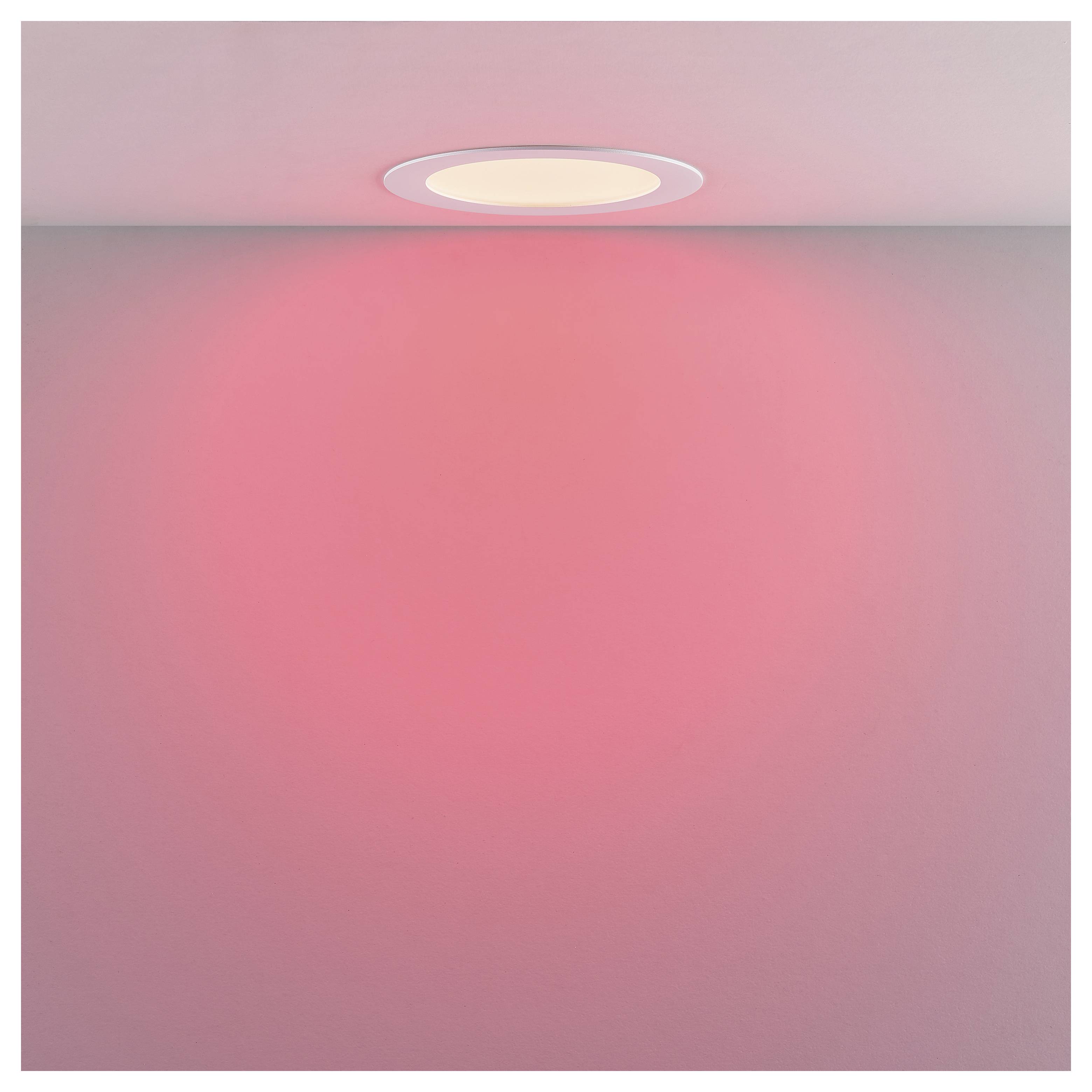 Ein Deckenleuchte wirft einen sanften rosa Schimmer über einen schlichten Raum oder eine kahle Wand.